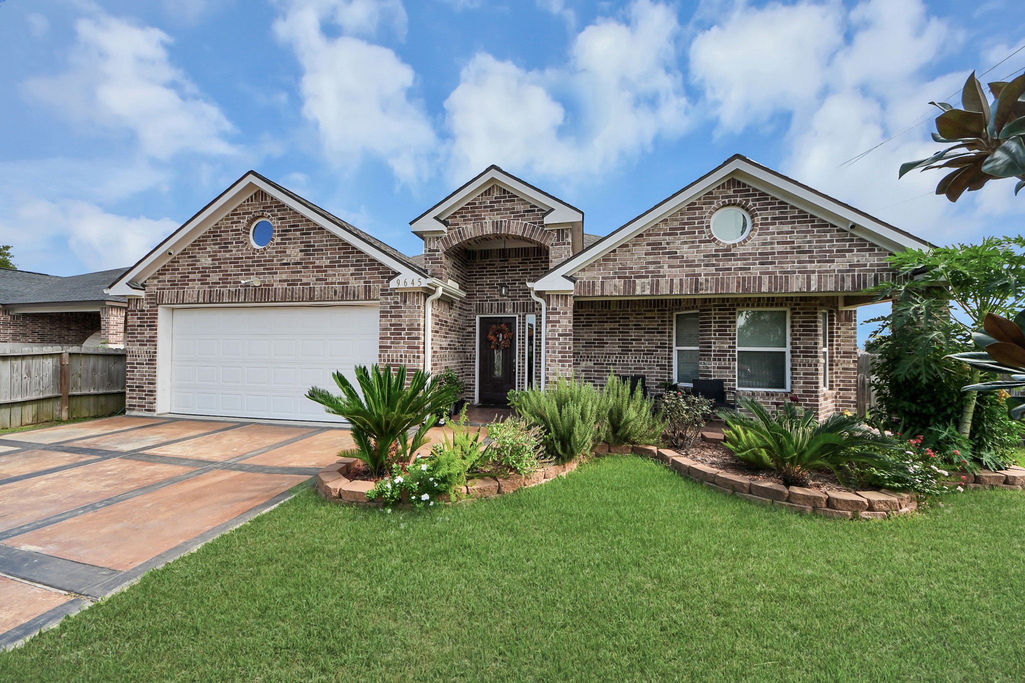 Front landscaping frames the brick facade and covered porch.