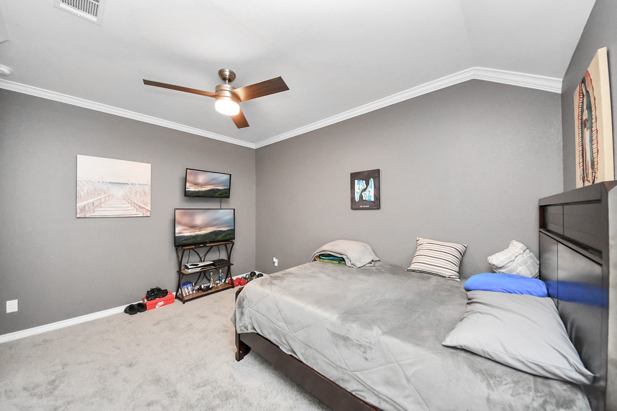 Another bedroom view highlights the wall space and ceiling fan.