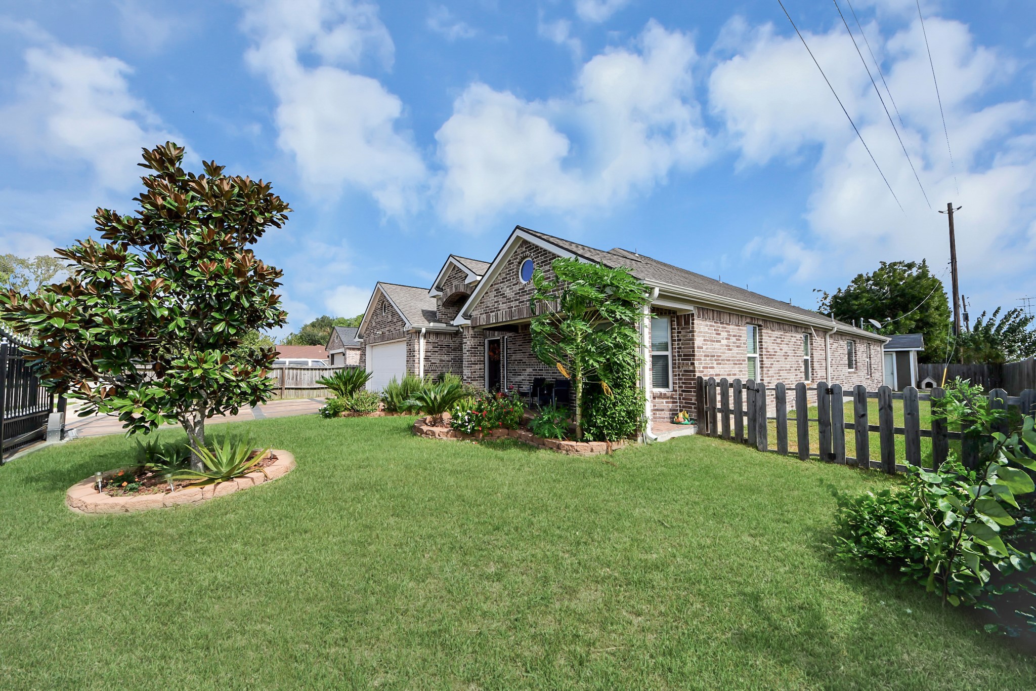Green front lawn with a view of the home and landscaping.