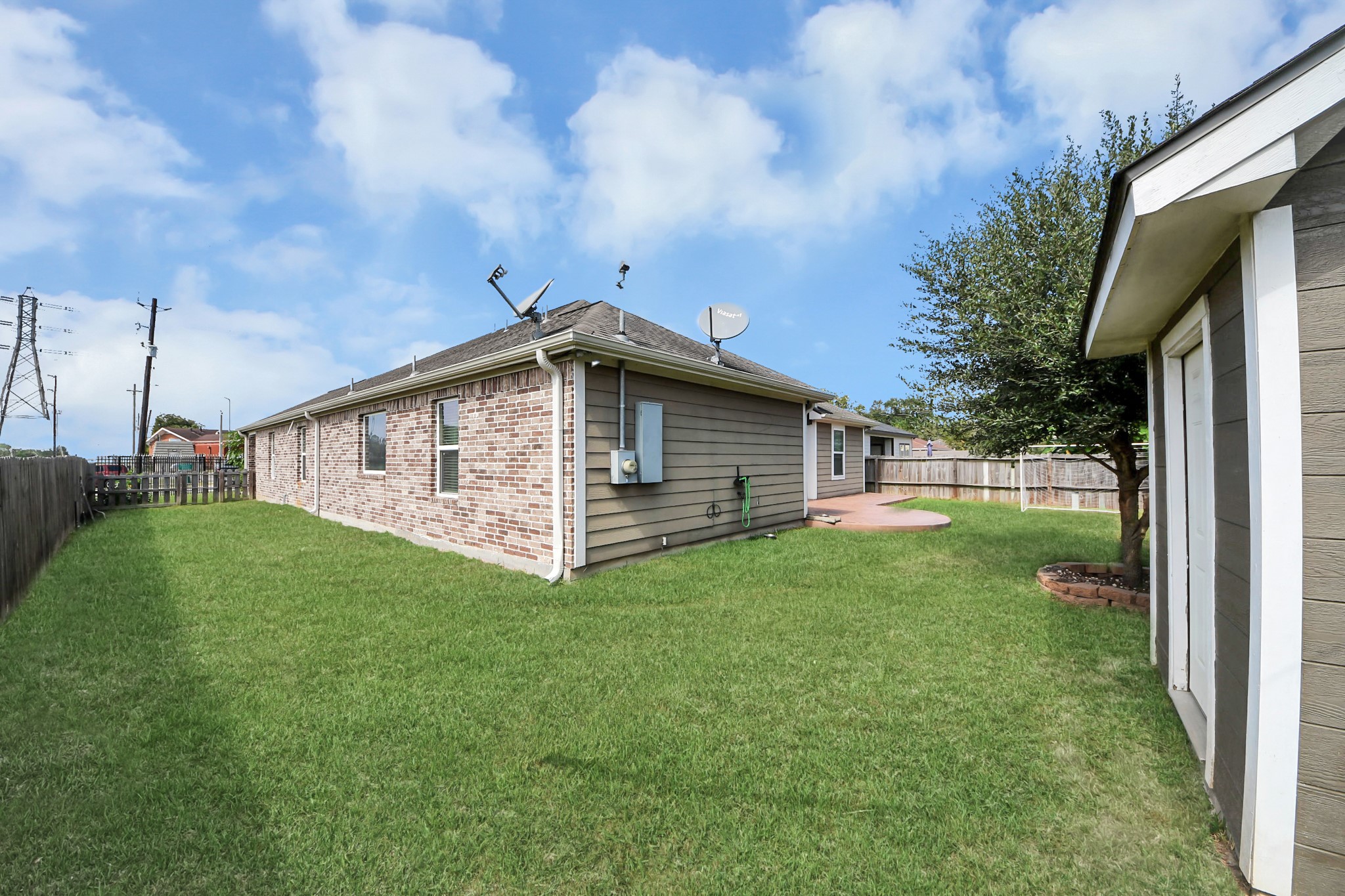 Side exterior view of the brick home and grassy yard.