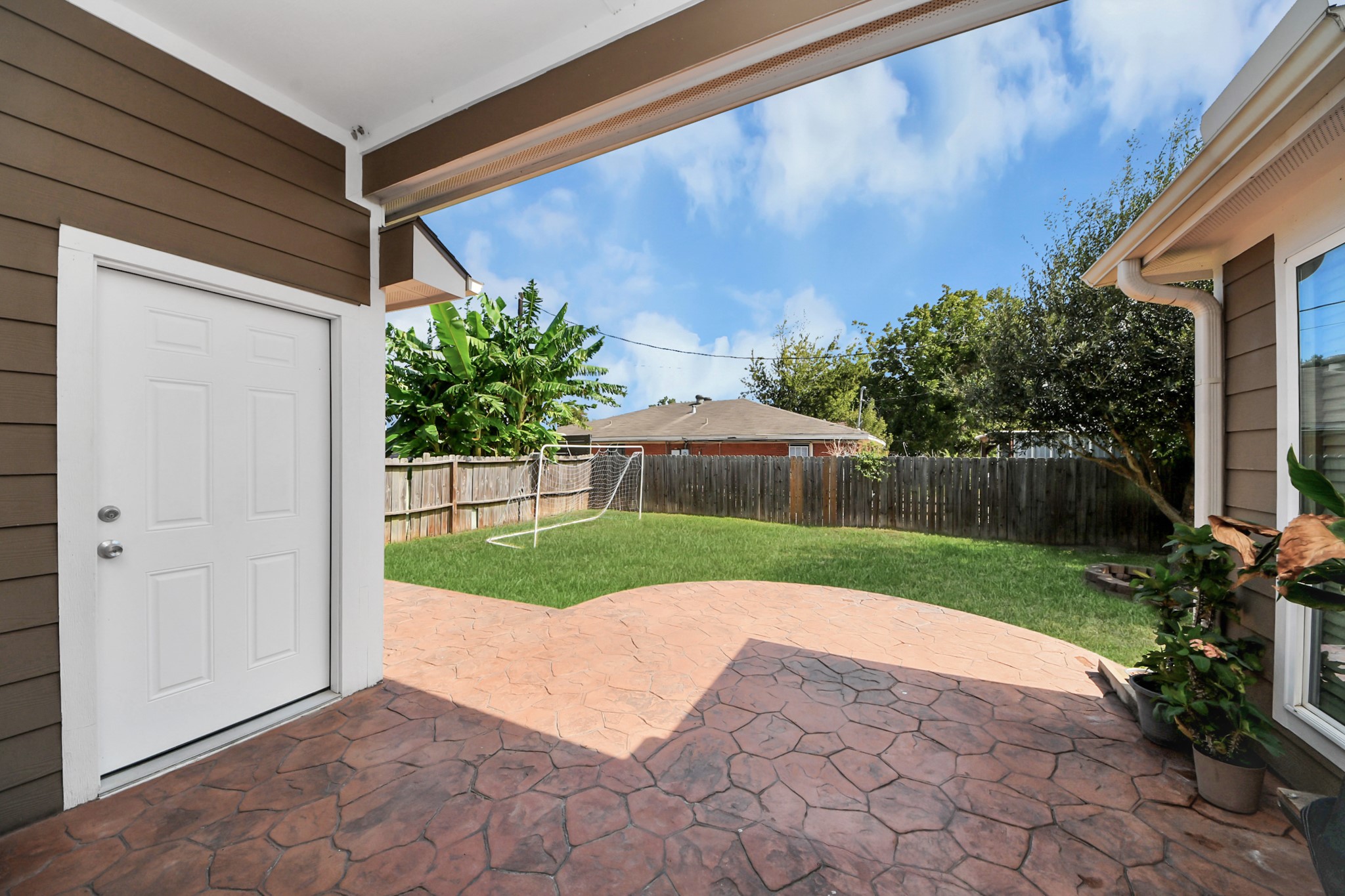 Covered patio opens to the lawn for outdoor living.