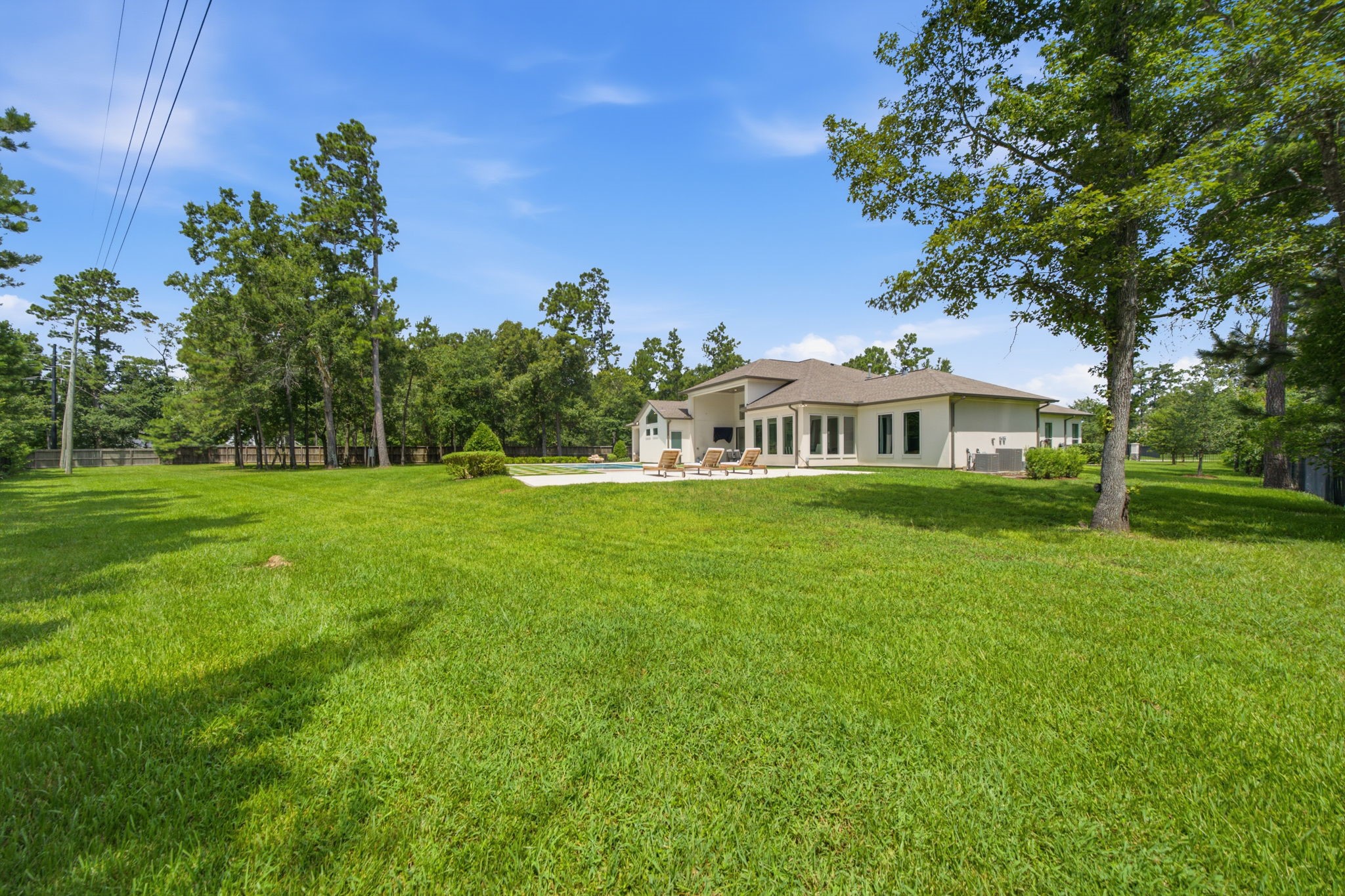 Expansive backyard with lush greenery and a spacious patio, perfect for outdoor relaxation and entertaining.