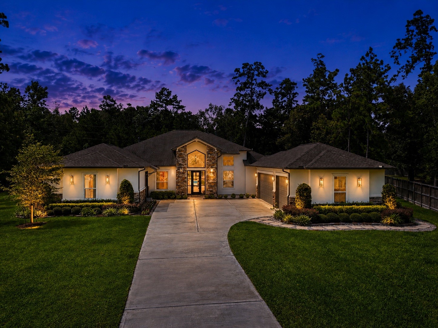 Stunning single-story home with elegant exterior lighting, a spacious driveway, and beautifully landscaped gardens, nestled against a backdrop of lush trees. Stunning single-story home with elegant exterior lighting, a spacious driveway, and beautifully landscaped gardens, nestled against a backdrop of lush trees.