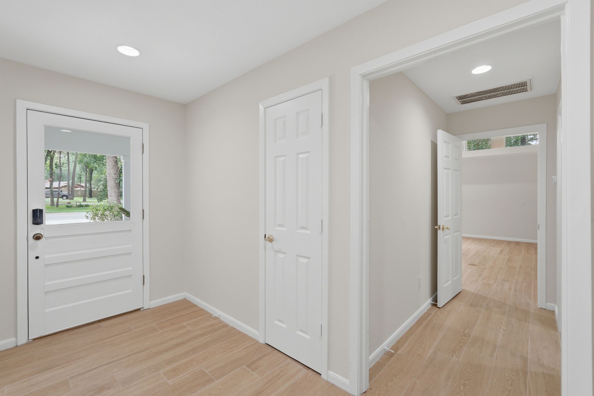 Just inside the door and to the left is a hallway with your laundry room and primary bedroom down it.