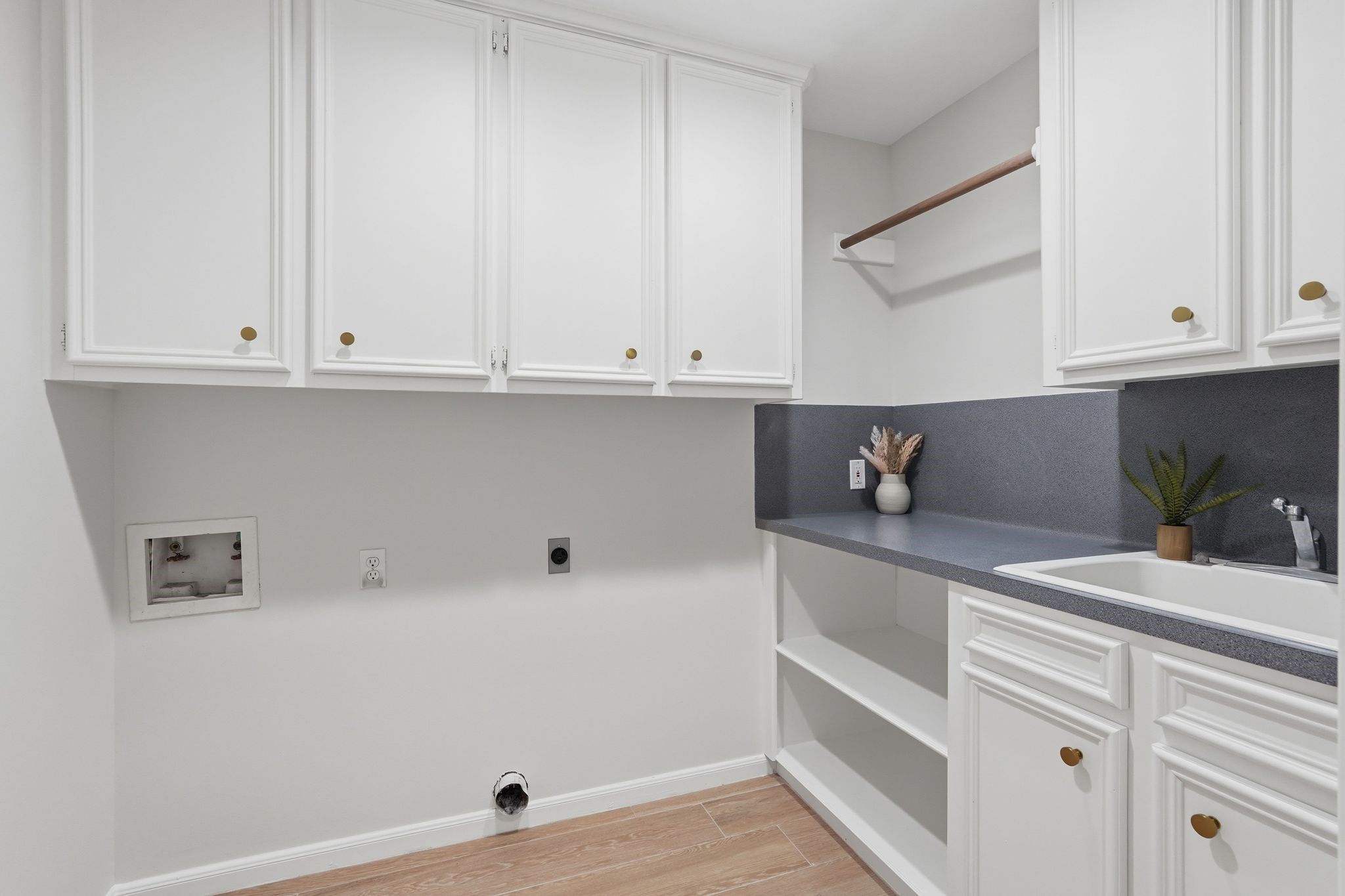 This laundry room has it all! It includes tons of storage, space to hang your clothes, a place to fold it AND a sink? YES PLEASE!