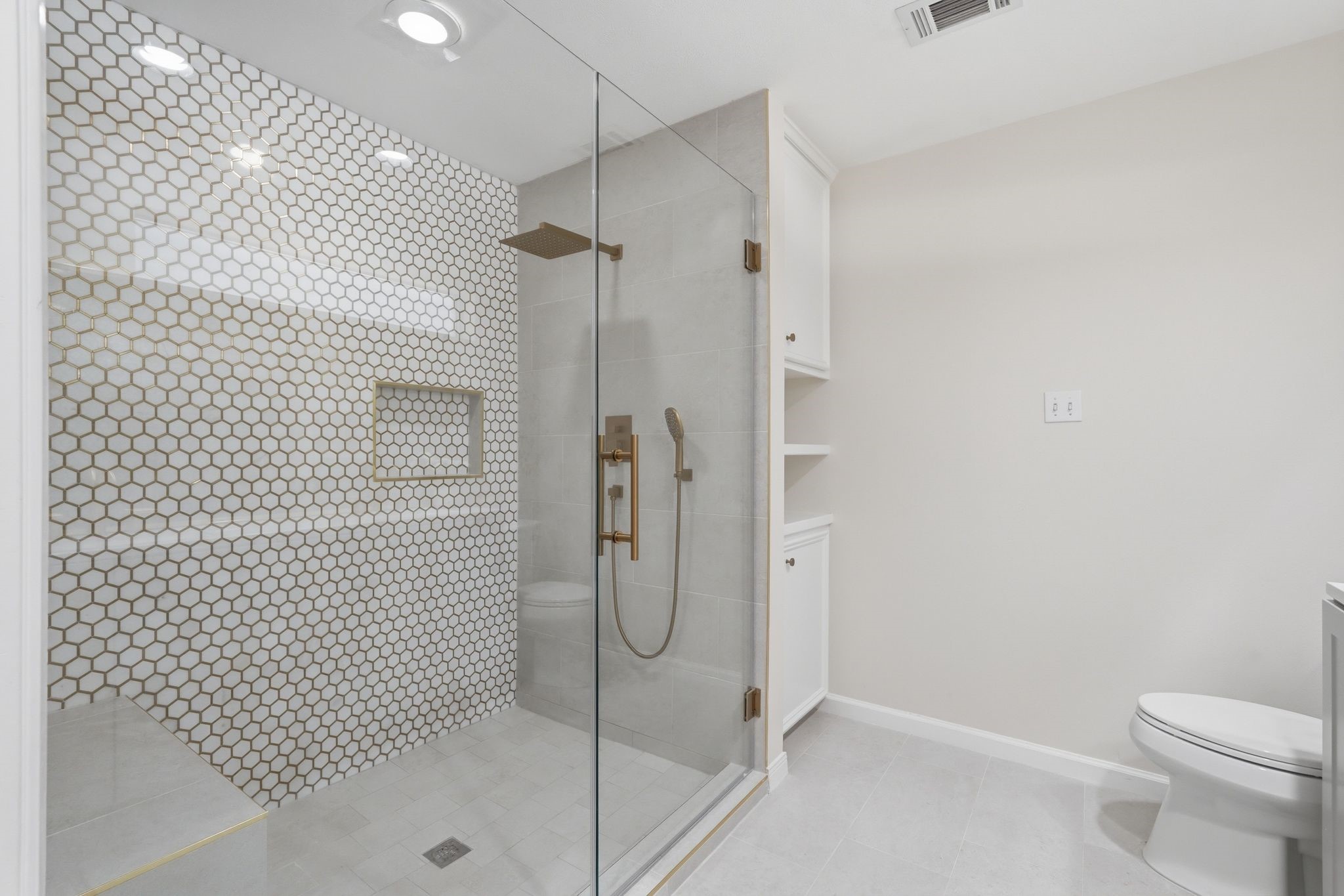 This shower is HUGE!! It has a rain shower head, a convenient place to store your toiletries and a bench seat!
