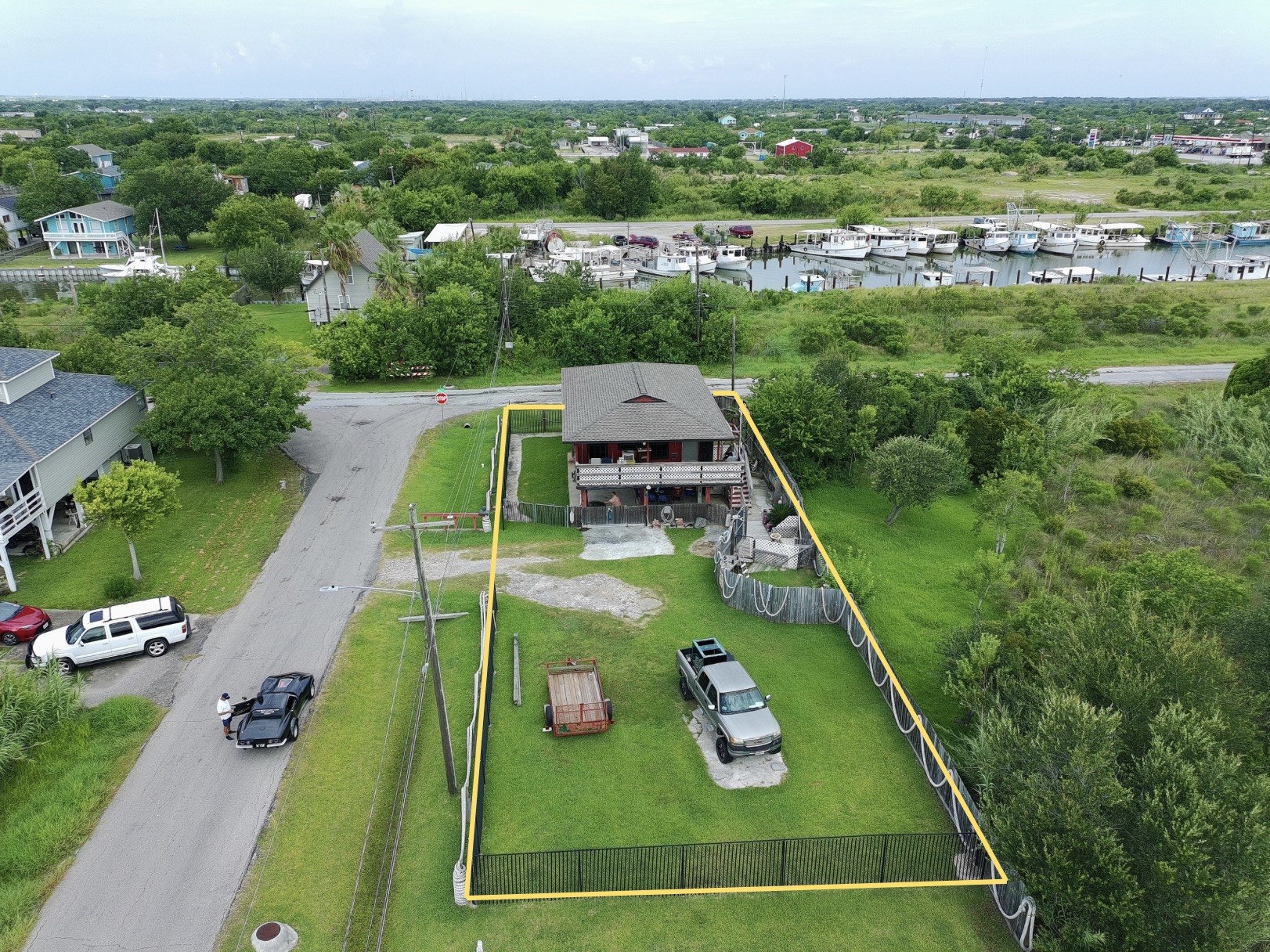overhead view shows proximity to water (red house) (yellow boundary lines are approximate, refer to provided survey)