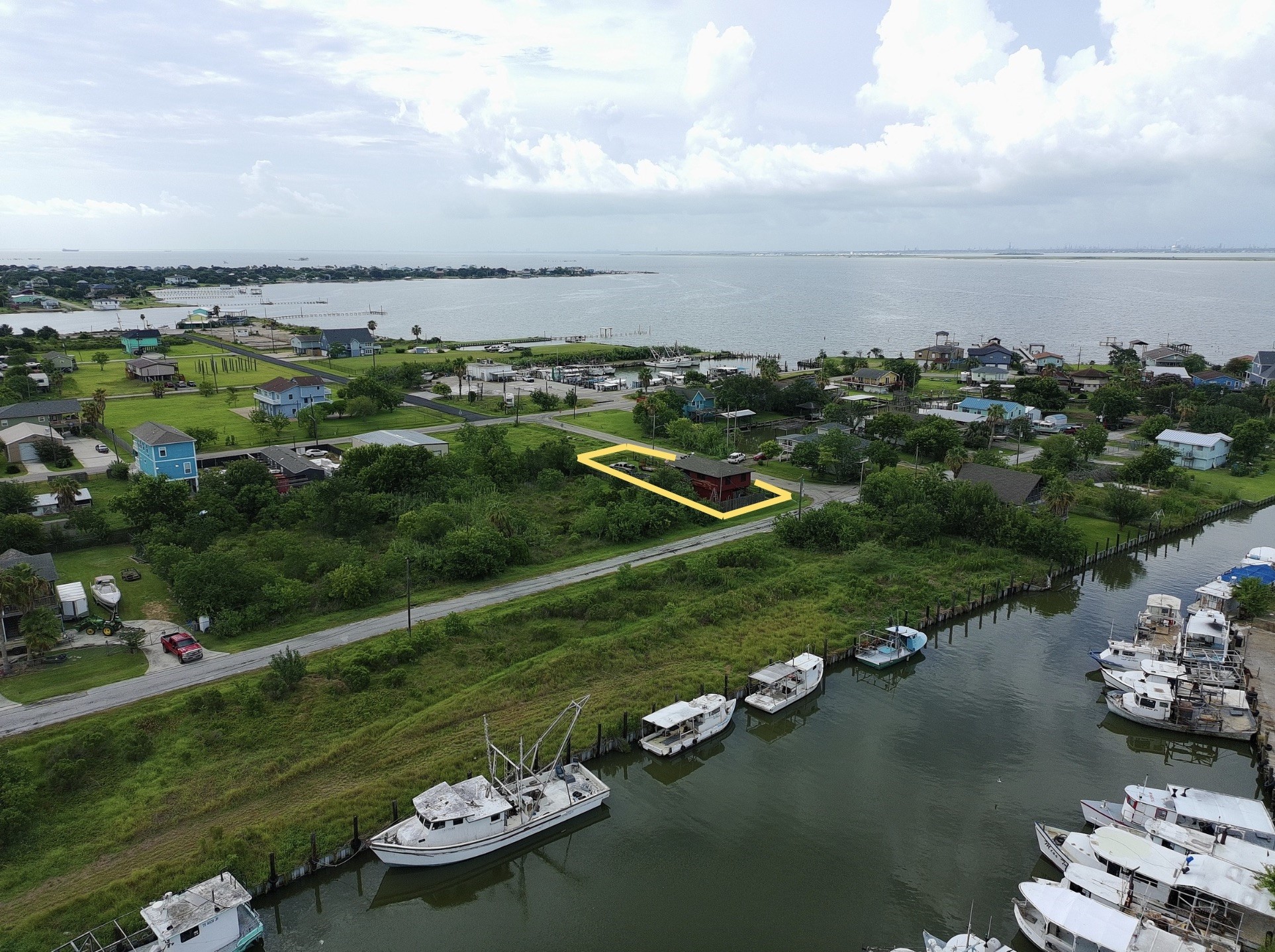 overhead view shows proximity to water (red house) (yellow boundary lines are approximate, refer to provided survey)