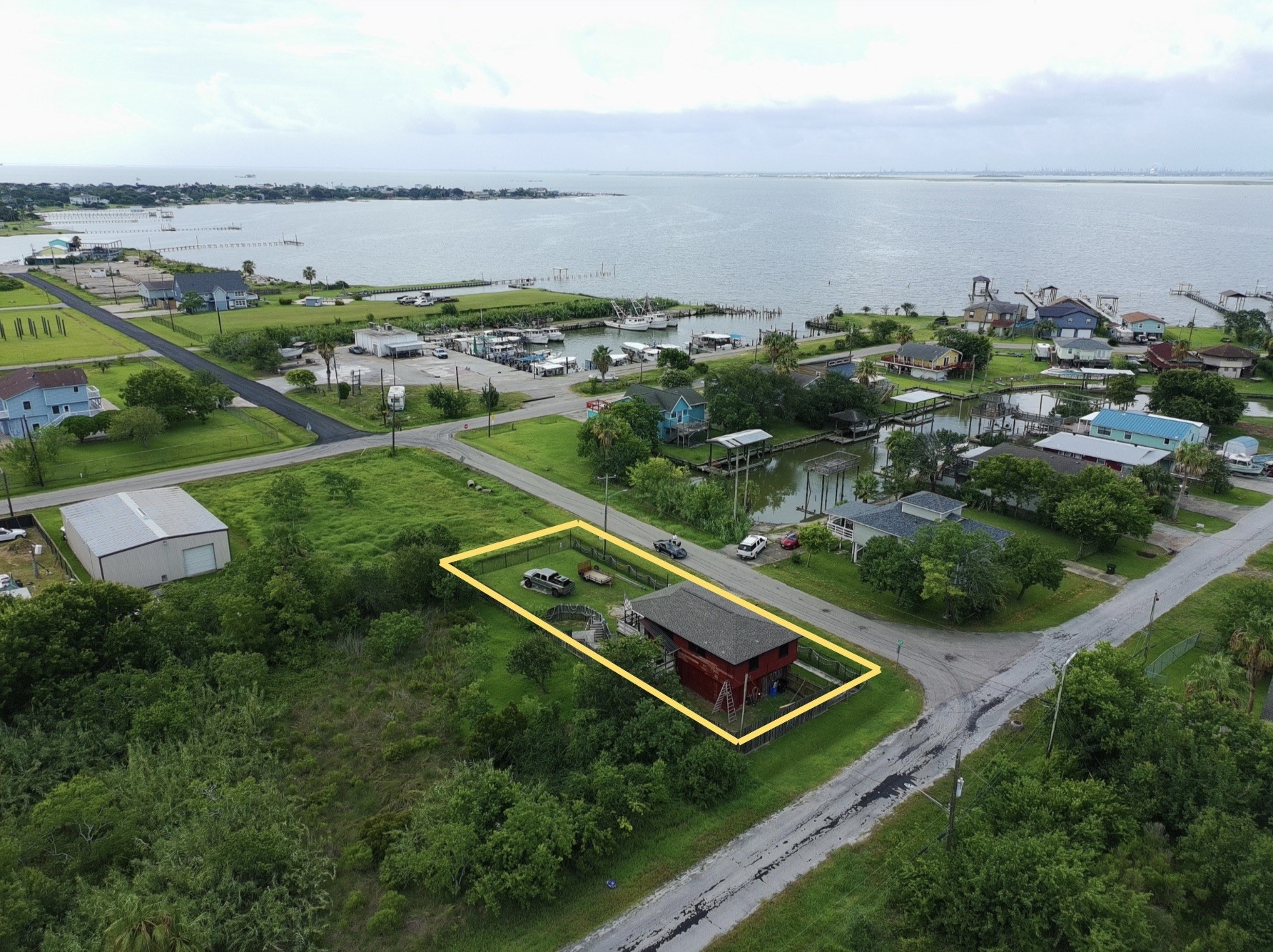 overhead view shows proximity to water (red house) (yellow boundary lines are approximate, refer to provided survey)
