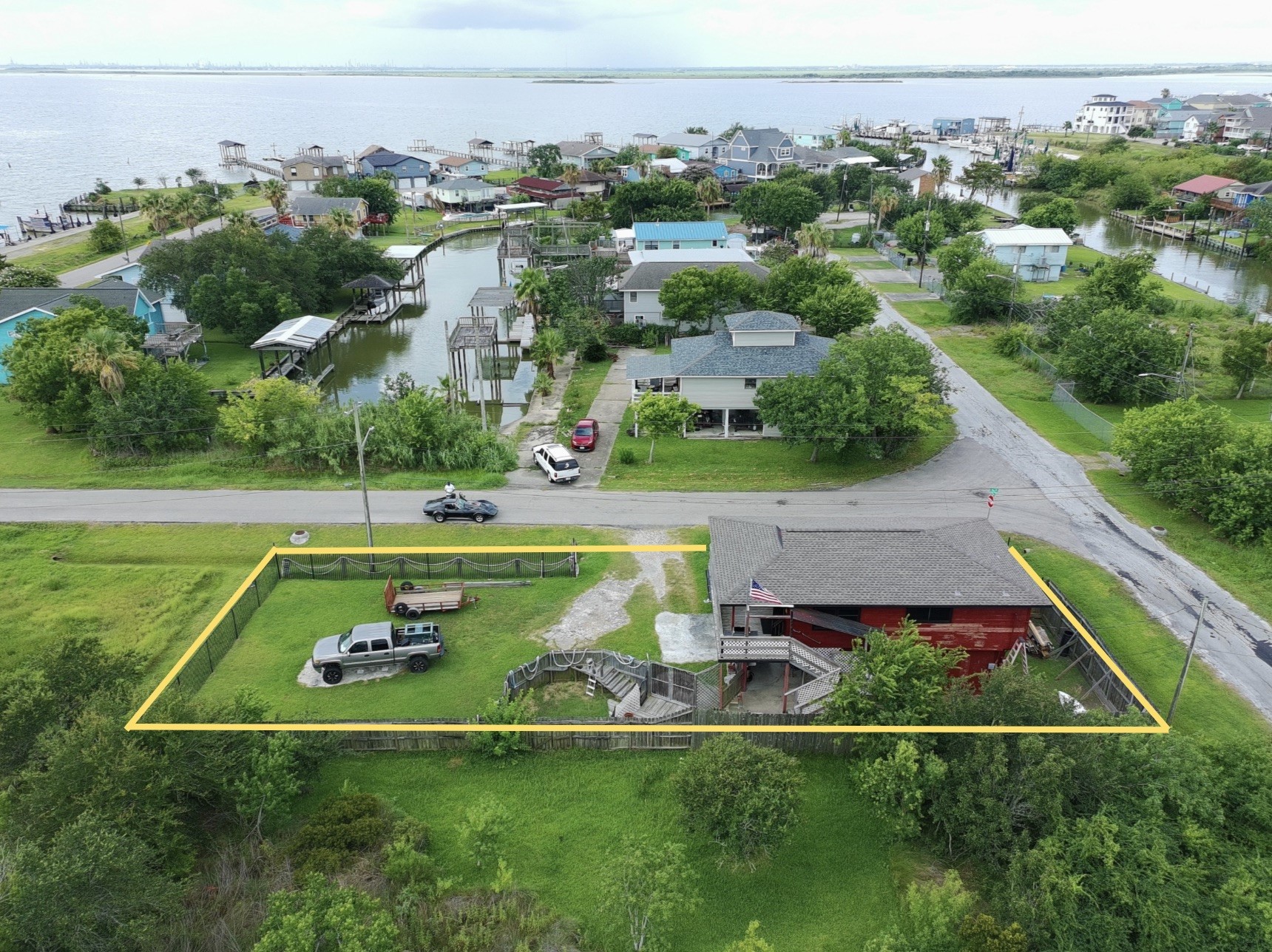 overhead view shows proximity to water (red house) (yellow boundary lines are approximate, refer to provided survey)