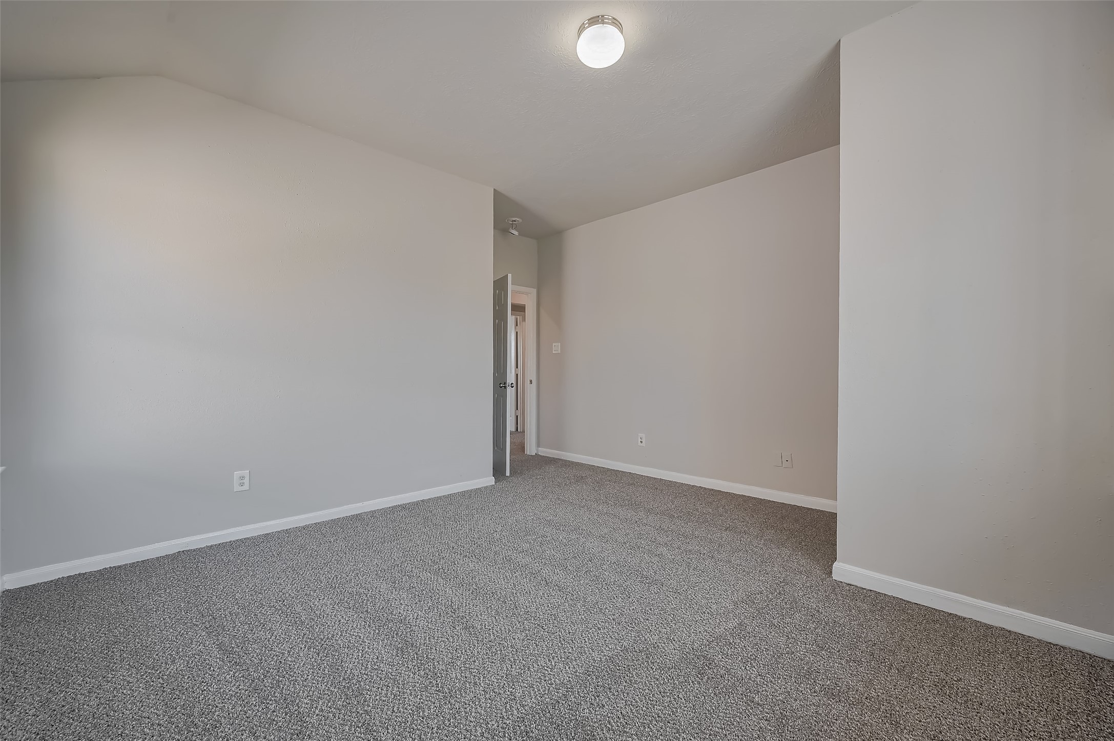 Bedroom with high ceilings & plush carpeting.