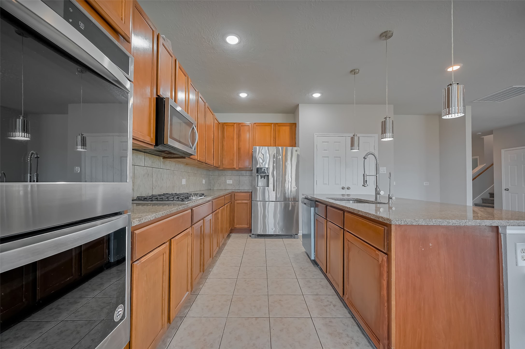 Kitchen with generous wood cabinetry and a large island.