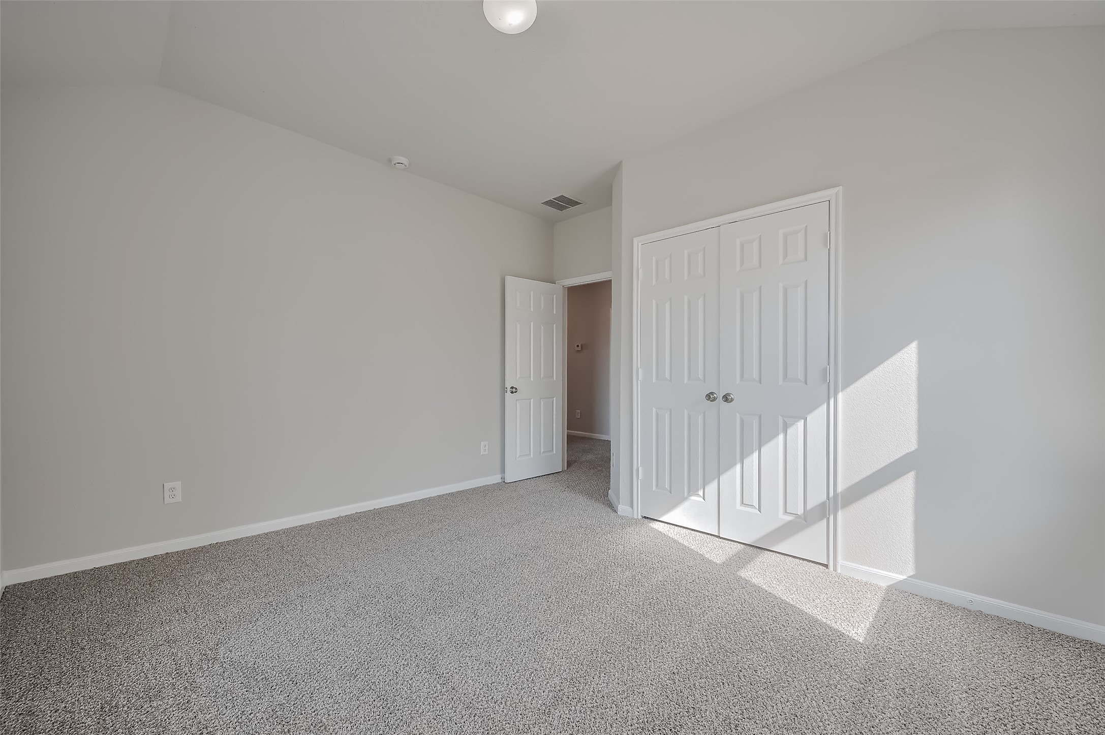 Bedroom with double-door closet and hallway access.