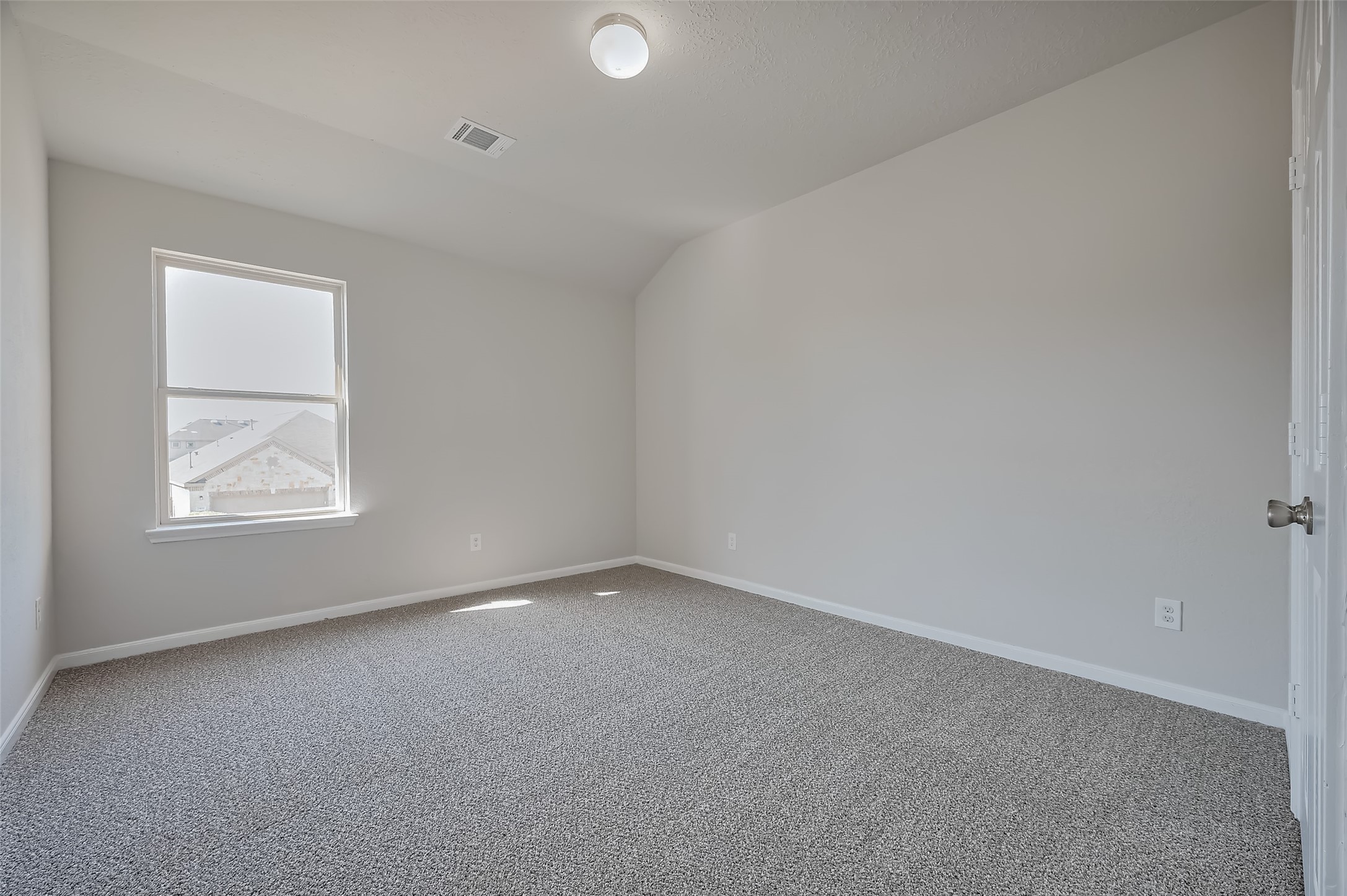 Bedroom with neutral walls and a carpeted floor.