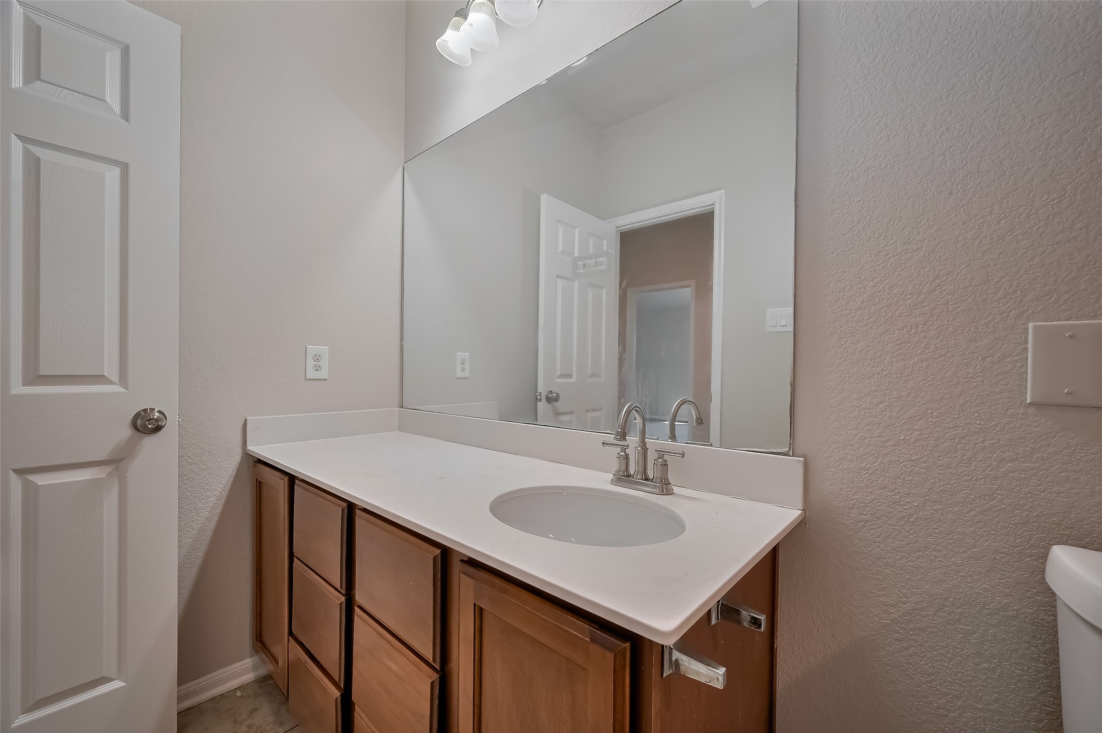 Modern bathroom with a large mirror & single sink vanity.