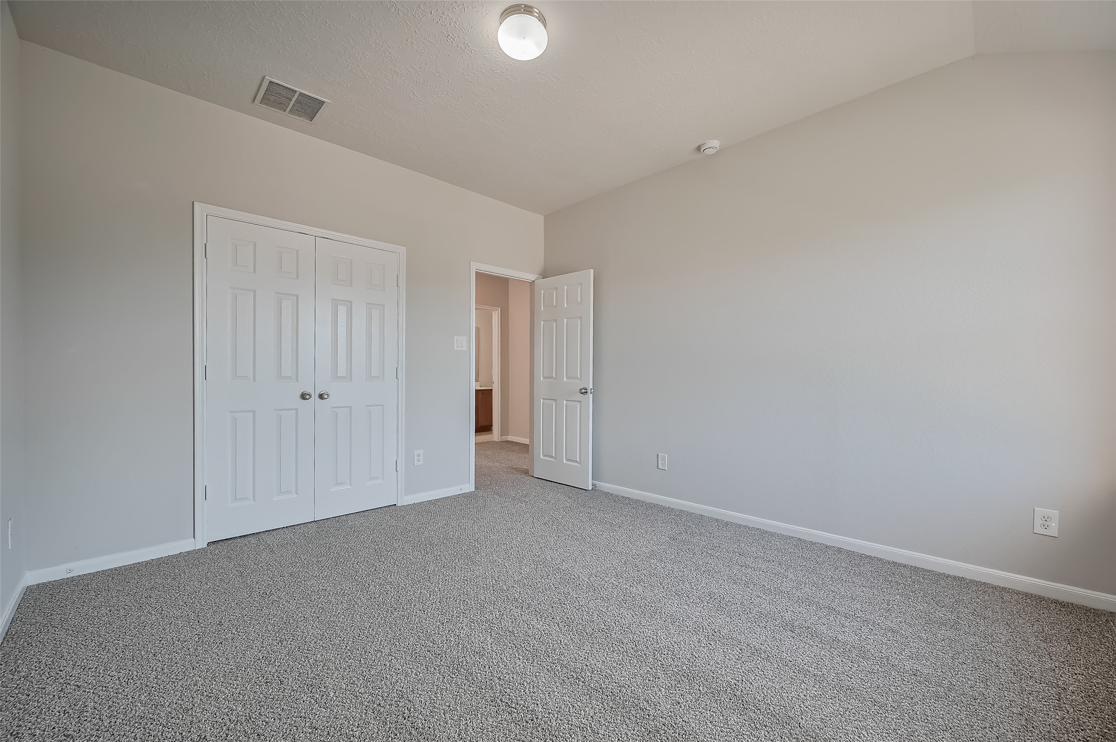 Bedroom features carpeting & a double-door closet.