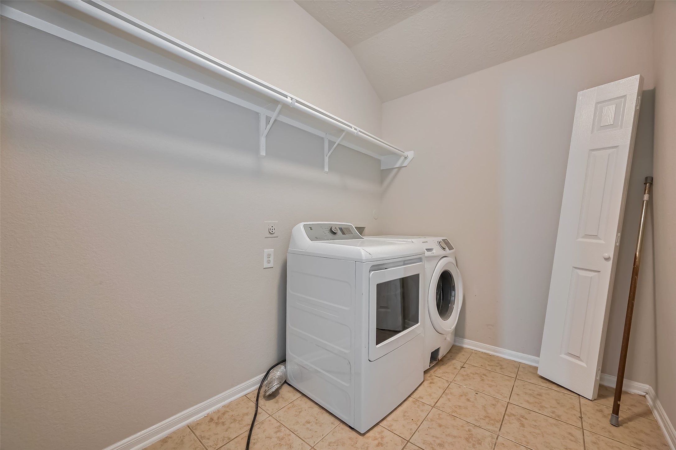 Laundry space features washer and dryer & a built-in shelf.
