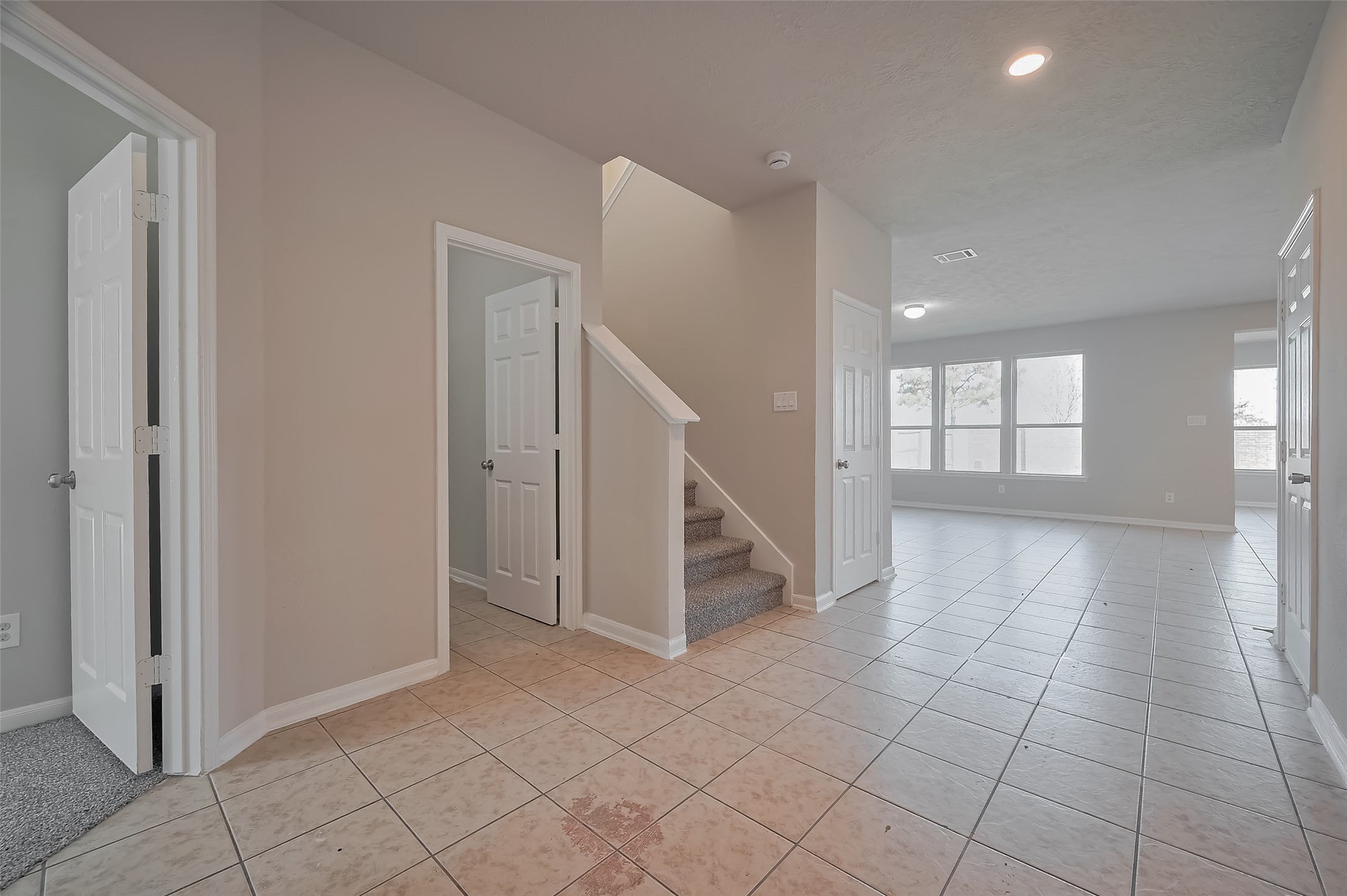 Inviting entryway with tile flooring and carpeted stairs. Inviting entryway with tile flooring and carpeted stairs.