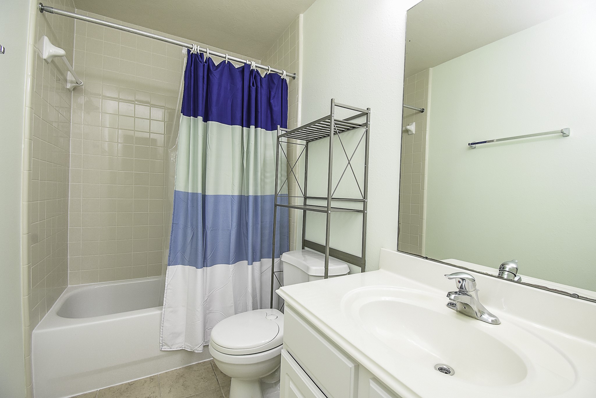 Secondary bathroom featuring a tiled tub and shower combination.
