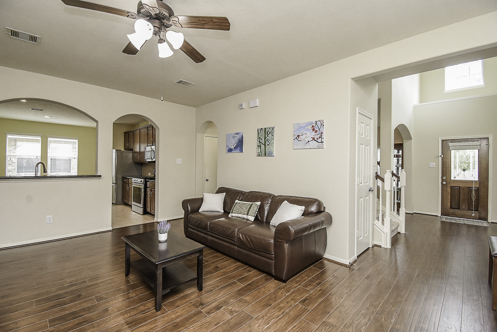 Another view showcasing the open layout and seamless flow between the living room, kitchen, and entryway.
