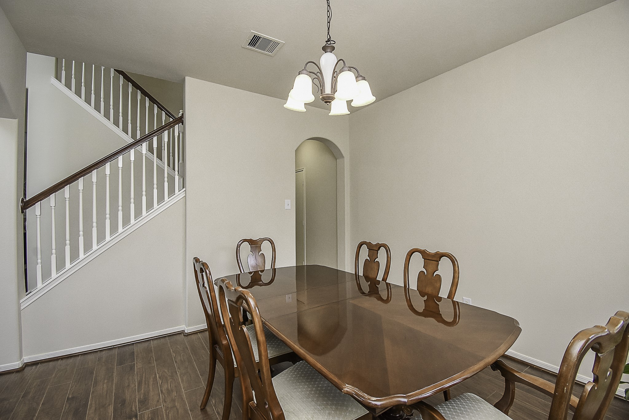 Step through the arched entryways that seamlessly connect the formal dining room to the spacious living area.