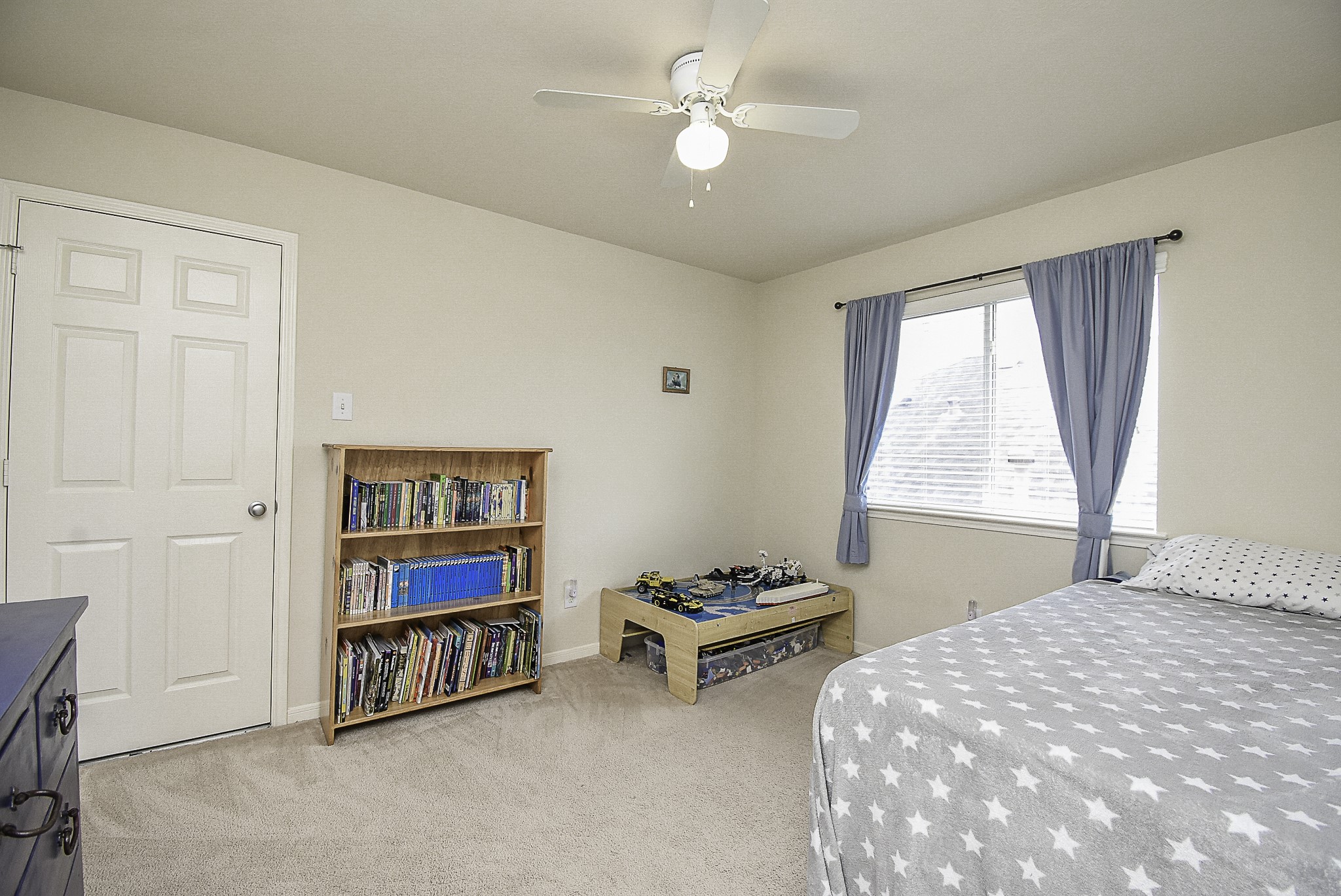 Spacious secondary bedroom featuring a ceiling fan and plenty of closet space.