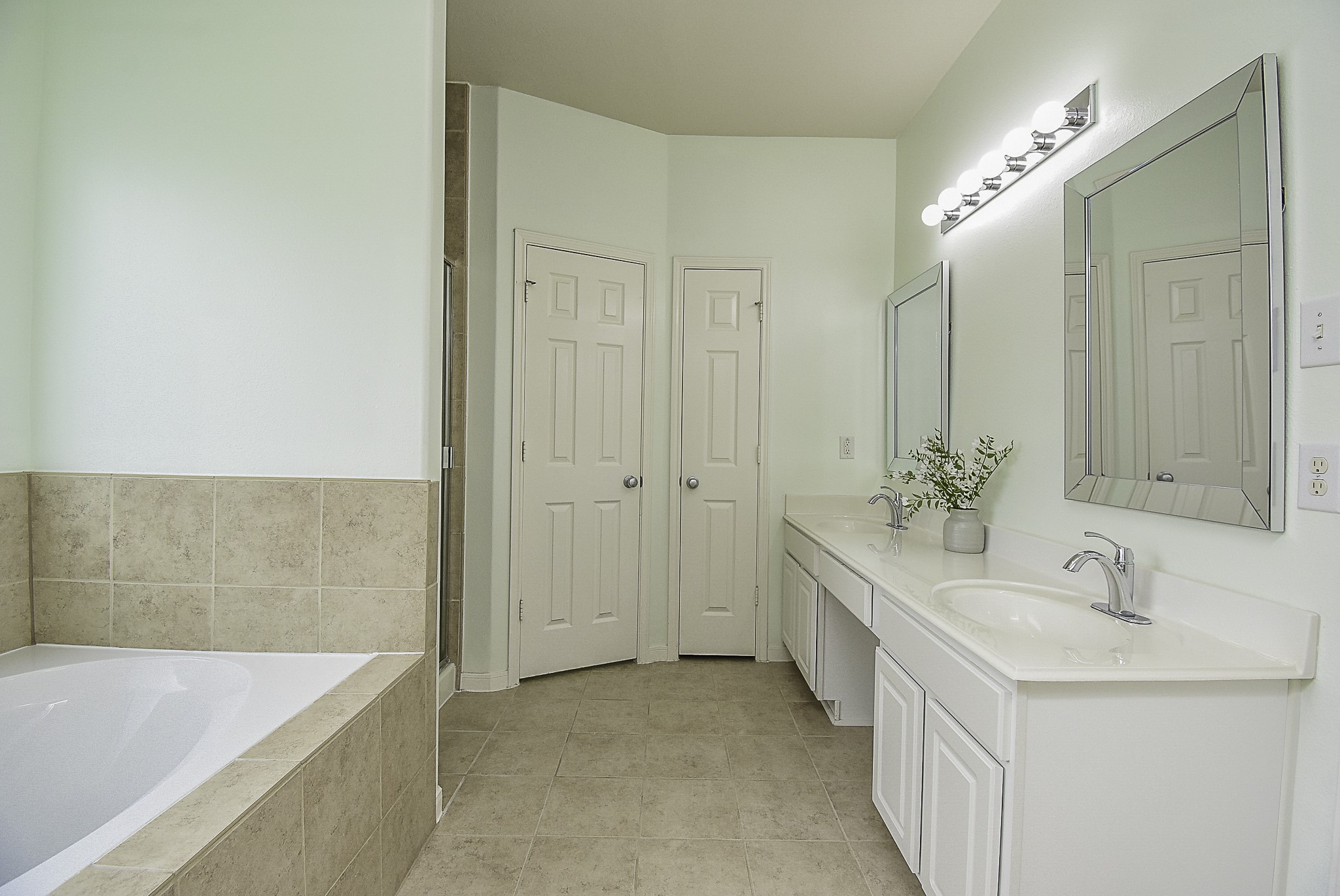 Spacious en-suite bathroom featuring dual vanities and a soaking tub.