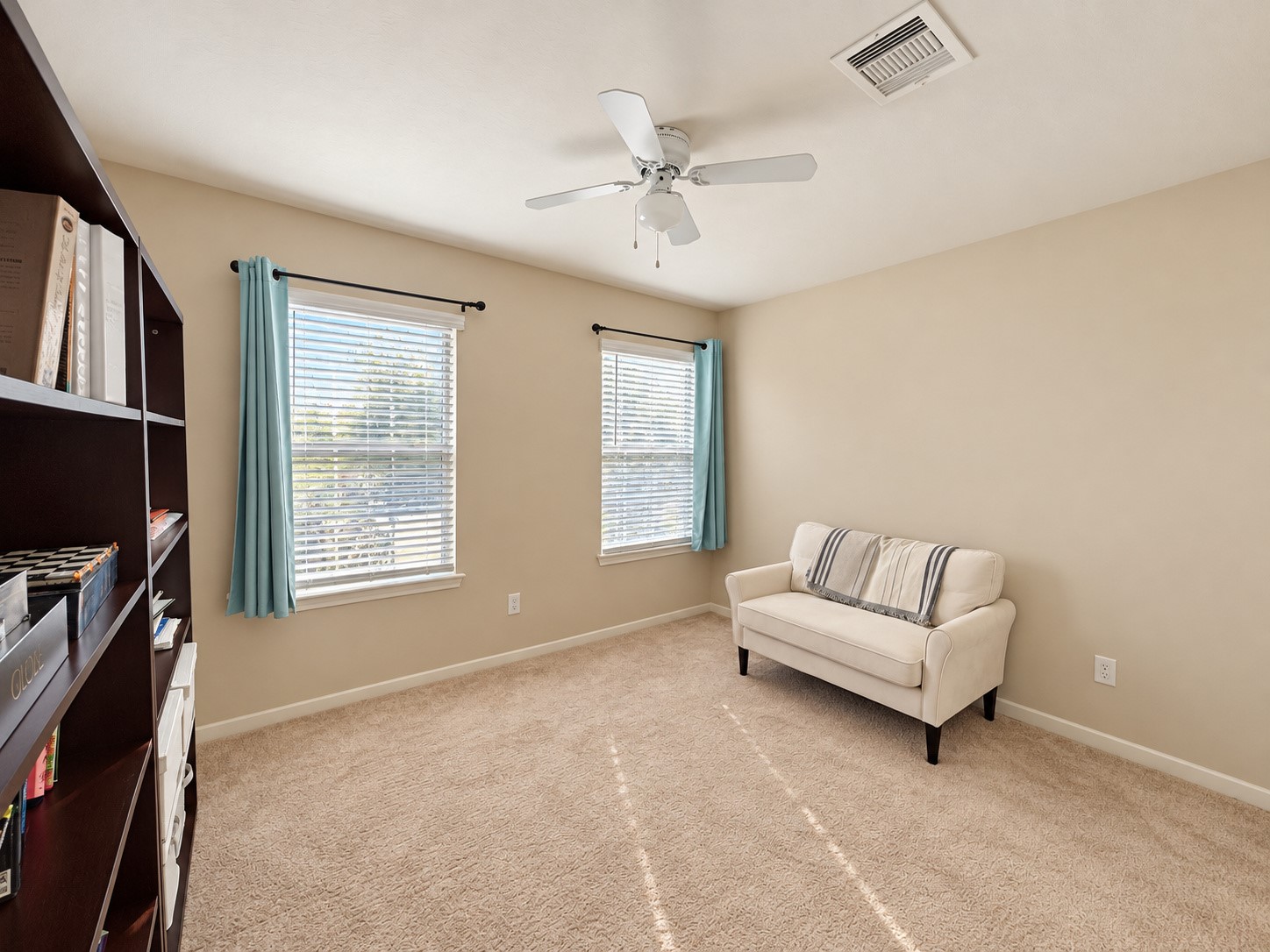 Spacious fourth bedroom featuring a ceiling fan and multiple windows for natural light.