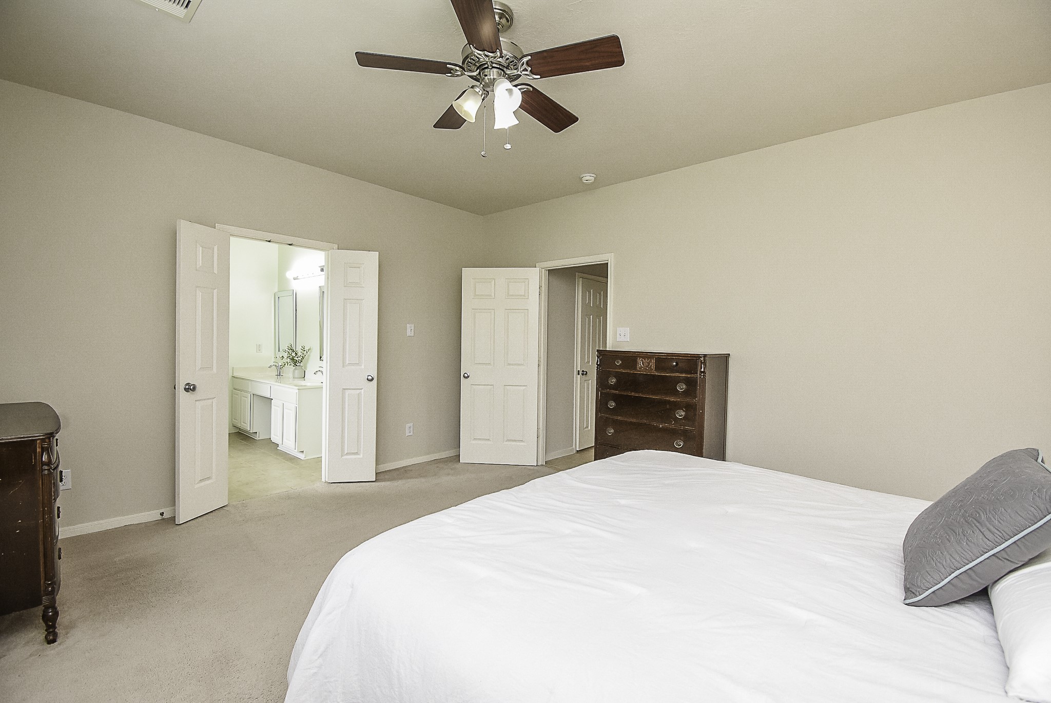 Spacious primary bedroom with a ceiling fan and convenient access to the en-suite bathroom.