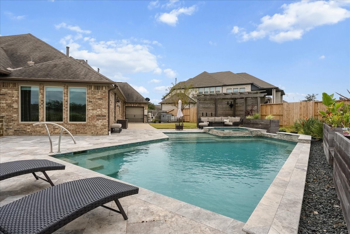 Your backyard paradise features a resort-style pool, spa, cedar pergola, covered patio, expansive travertine decking, and outdoor kitchen designed for entertaining!