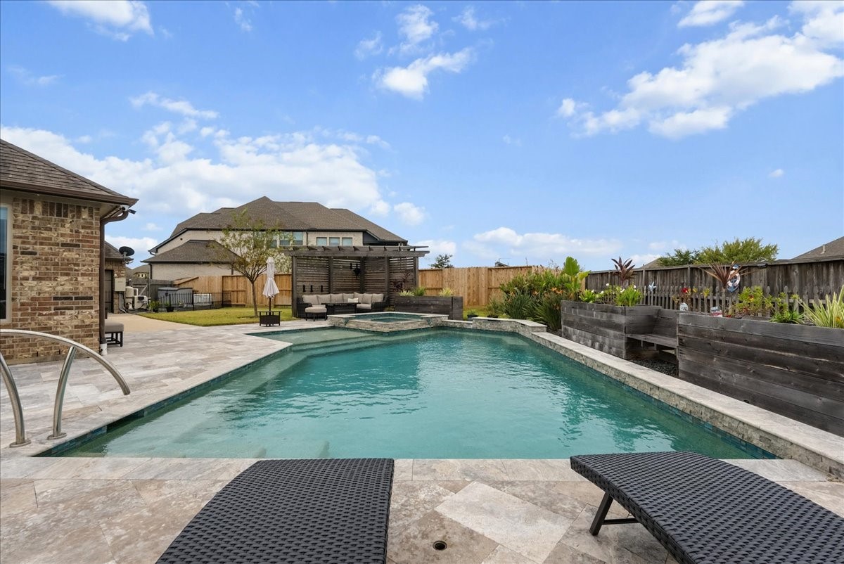 Your backyard paradise features a resort-style pool, spa, cedar pergola, covered patio, expansive travertine decking, and outdoor kitchen designed for entertaining!