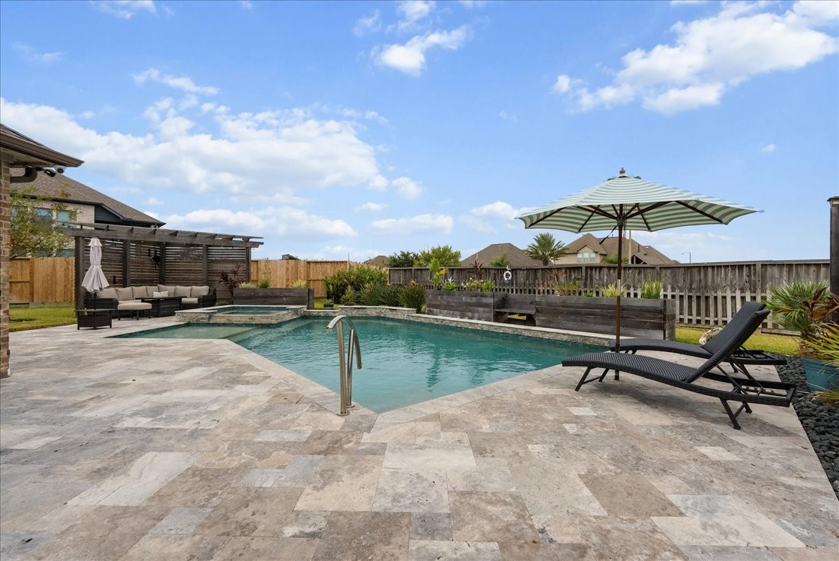 Your backyard paradise features a resort-style pool, spa, cedar pergola, covered patio, expansive travertine decking, and outdoor kitchen designed for entertaining!