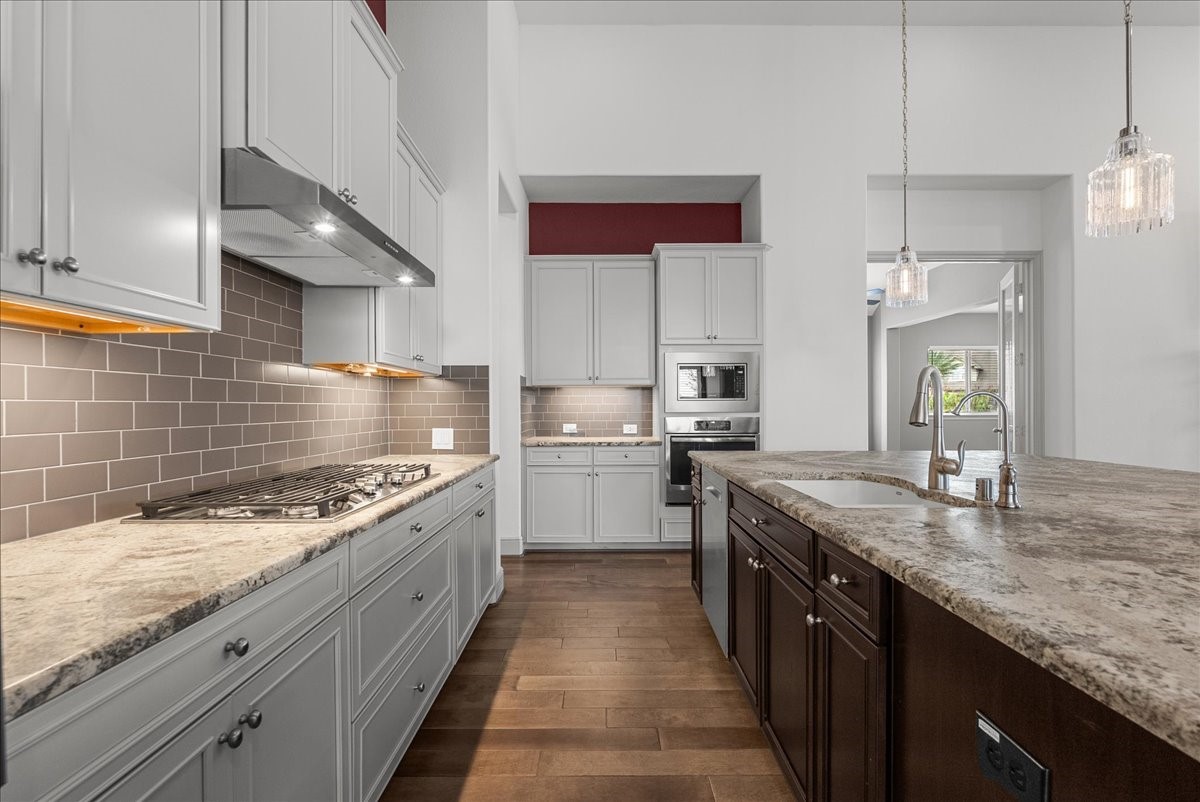 The gourmet kitchen impresses with an oversized granite island, stainless steel appliances, under cabinet lighting, walk-in pantry, and abundant cabinetry.