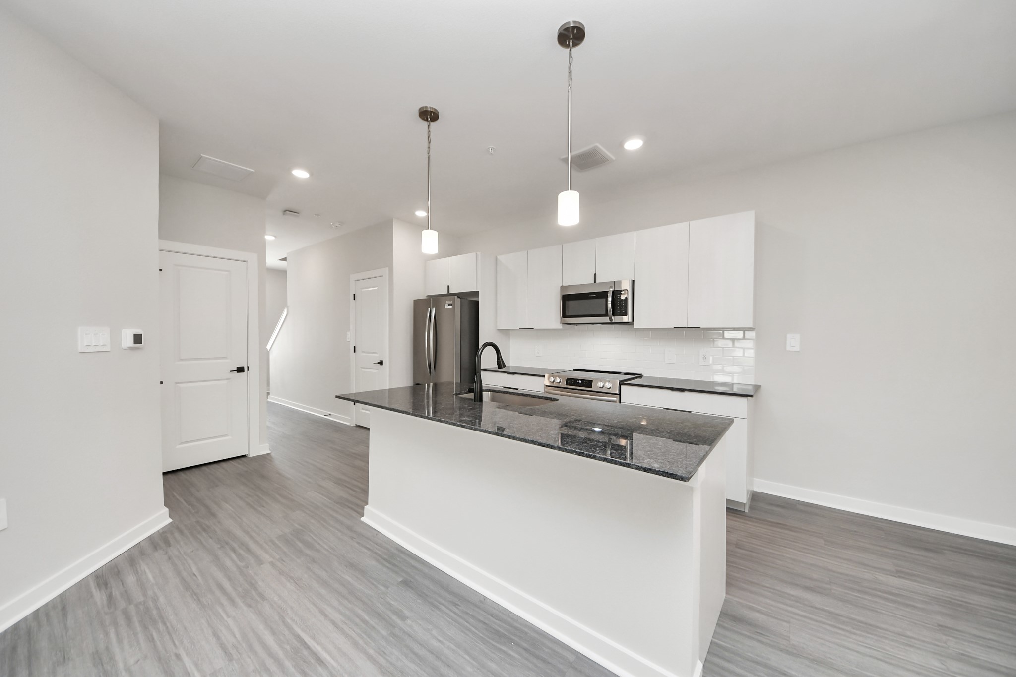 Boasting luxury finishes-stylish Island kitchen,granite counters,subway tile backsplash,ample custom cabinet space,stainless appliances,refrigerator,full size washer&dryer included,wood-like floors throughout,open concept floor plan.