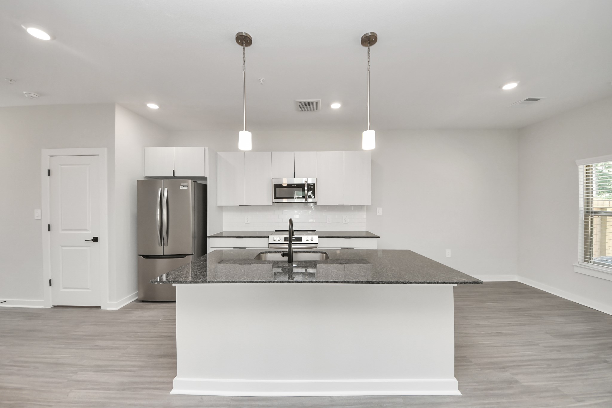 Boasting luxury finishes-stylish Island kitchen,granite counters,subway tile backsplash,ample custom cabinet space,stainless appliances,refrigerator,full size washer&dryer included,wood-like floors throughout,open concept floor plan.