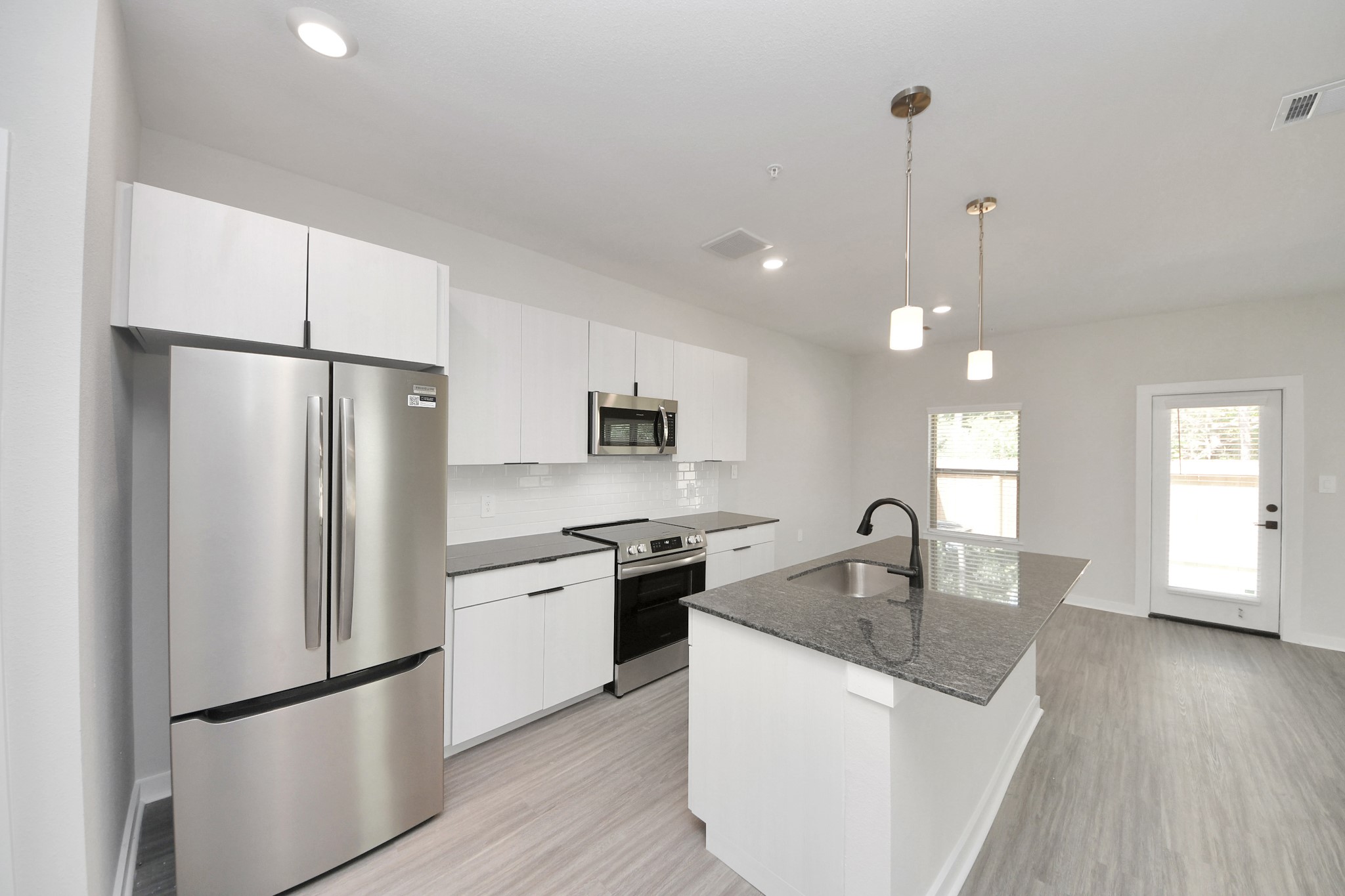 Boasting luxury finishes-stylish Island kitchen,granite counters,subway tile backsplash,ample custom cabinet space,stainless appliances,refrigerator,full size washer&dryer included,wood-like floors throughout,open concept floor plan.