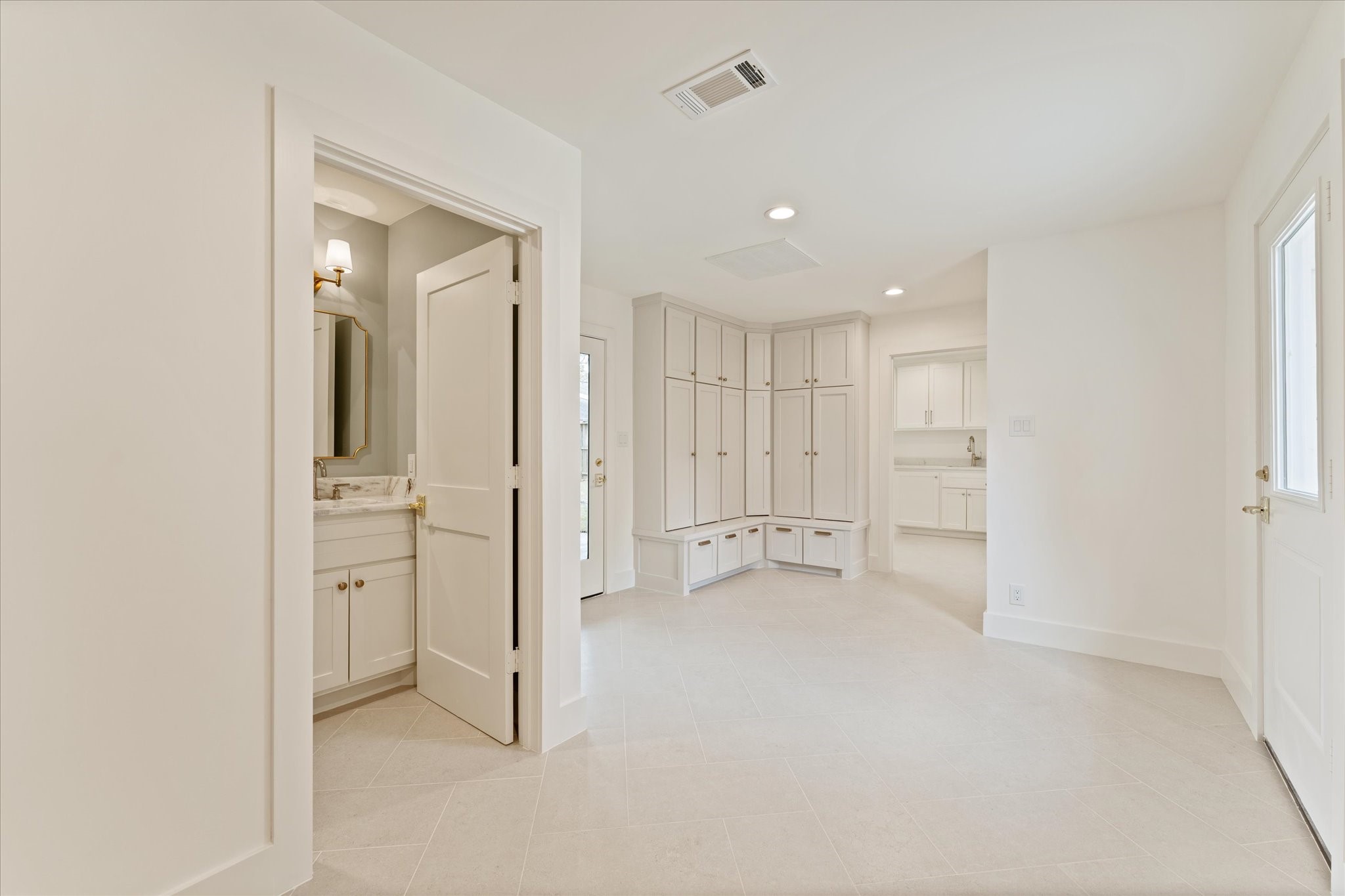 Entering into the expanded floorplan, is a 1/2 bath, mud room (with door into driveway and back patio) and oversized laundry room