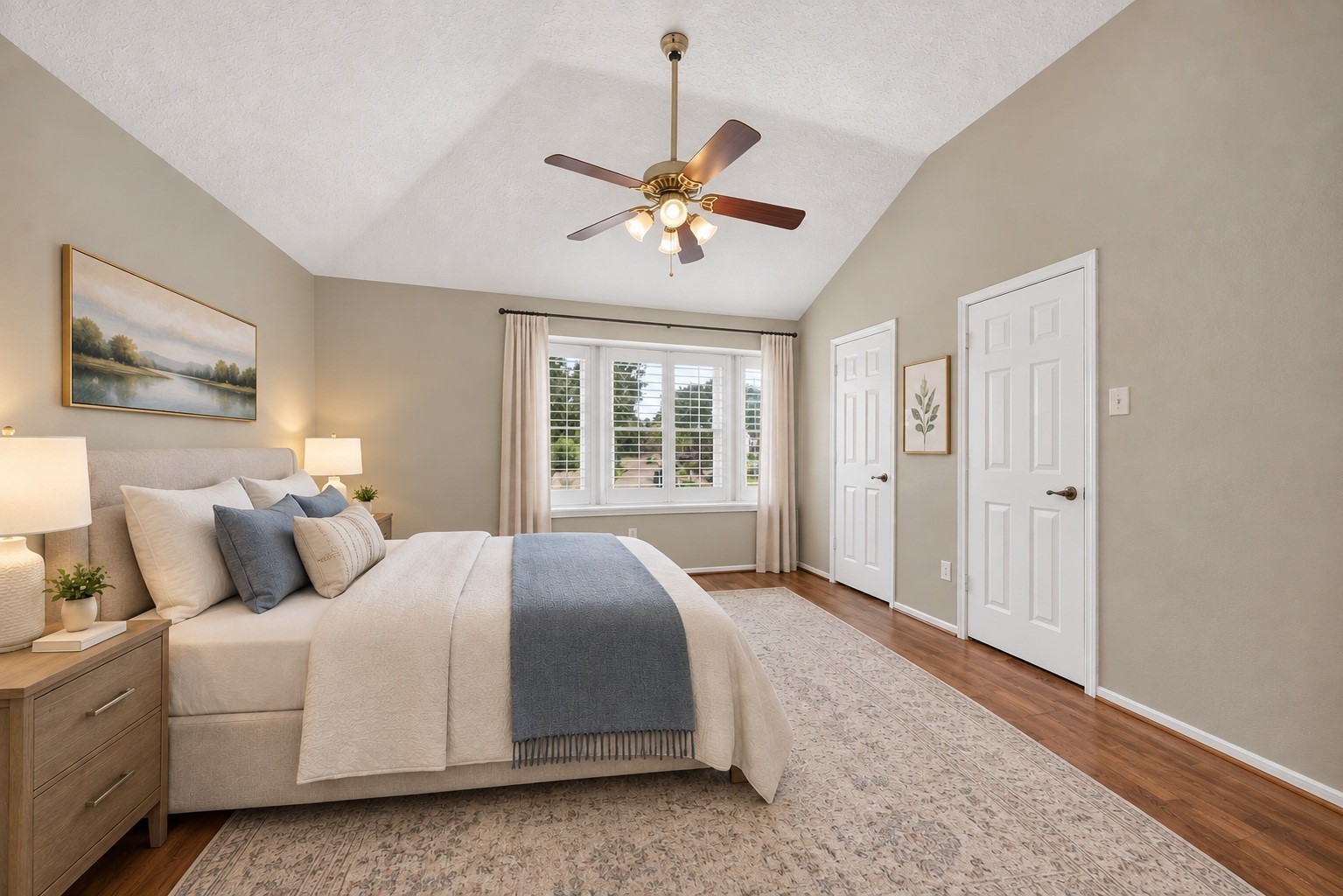A quiet, spacious upper-level master's bedroom featuring warm wood-look flooring, high ceilings, and lovely natural light. (virtual staged)