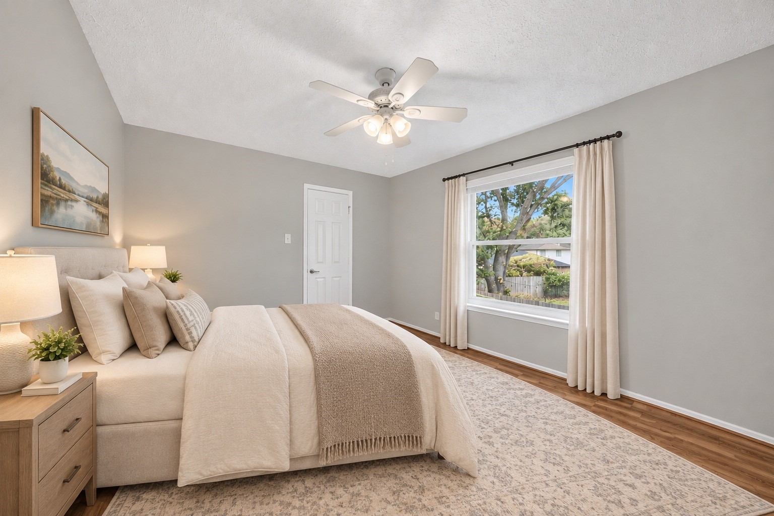 A spacious and bright second bedroom featuring warm wood-look flooring and a crisp, neutral paletteoffering a cozy, restful haven for family members or guests. (virtual staged)