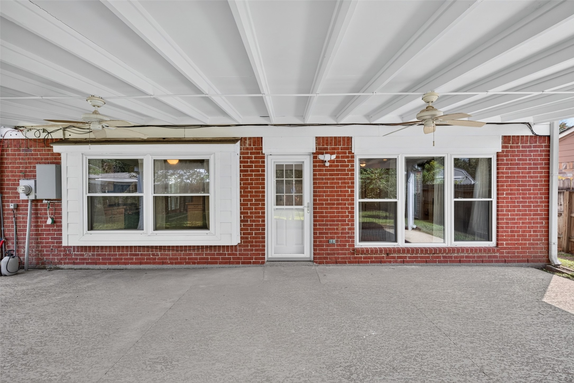 A spacious covered patio designed for effortless outdoor living, complete with ceiling fans and ample space for comfortable seating and alfresco dining.