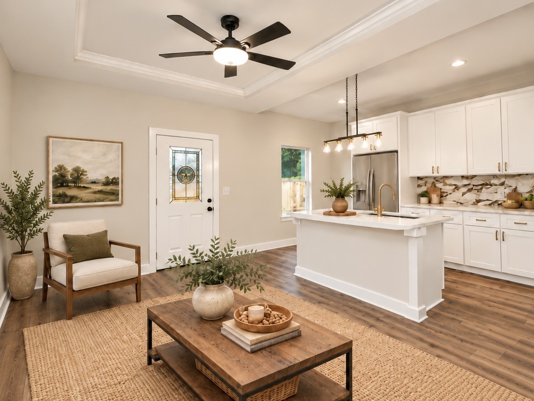 Designed with everyday living in mind, the open-concept family room connects directly to the kitchen, where quartz countertops, soft-close cabinetry, and an island provide both style and functionality. | Virtually Staged