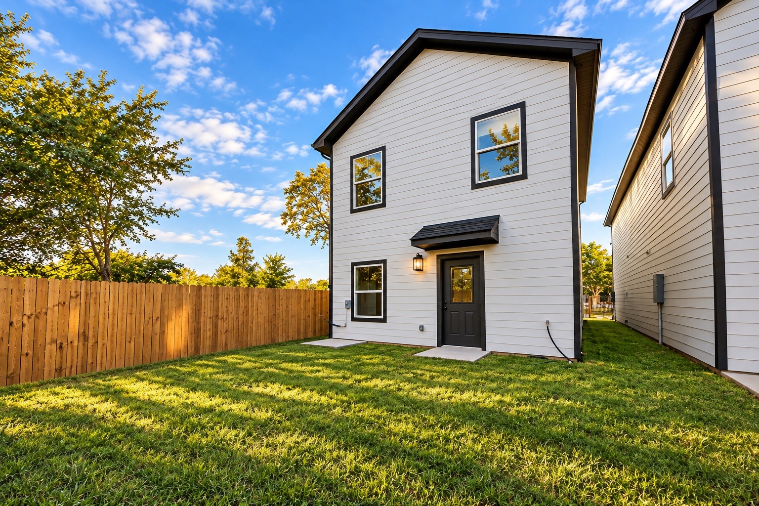 The fully fenced backyard offers private outdoor space with room for relaxing, gardening, or enjoying time outside. The home's rear elevation continues the clean architectural style found throughout the property.
