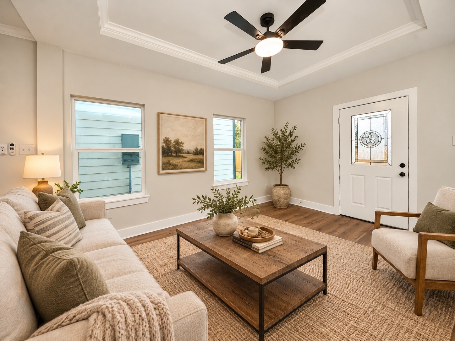 The family room features a decorative tray ceiling, ceiling fan, recessed lighting, and energy-efficient windows that bring in natural light. Its open layout creates a comfortable connection to the dining area and kitchen. | Virtually Staged