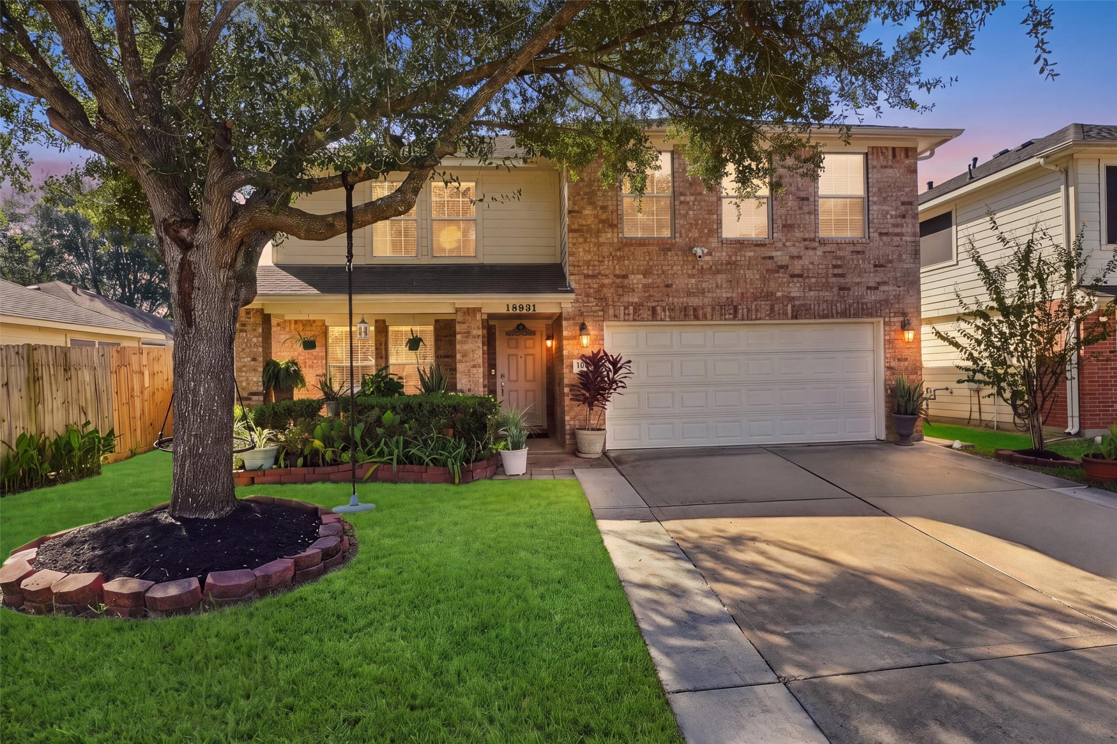 Charming two-story brick home with a spacious driveway, lush landscaping, and a welcoming front porch nestled under a large, beautiful tree. Charming two-story brick home with a spacious driveway, lush landscaping, and a welcoming front porch nestled under a large, beautiful tree.