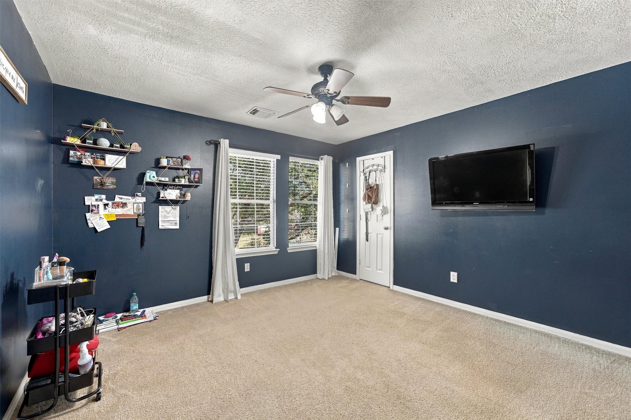 Spacious bedroom and large window offering natural light.