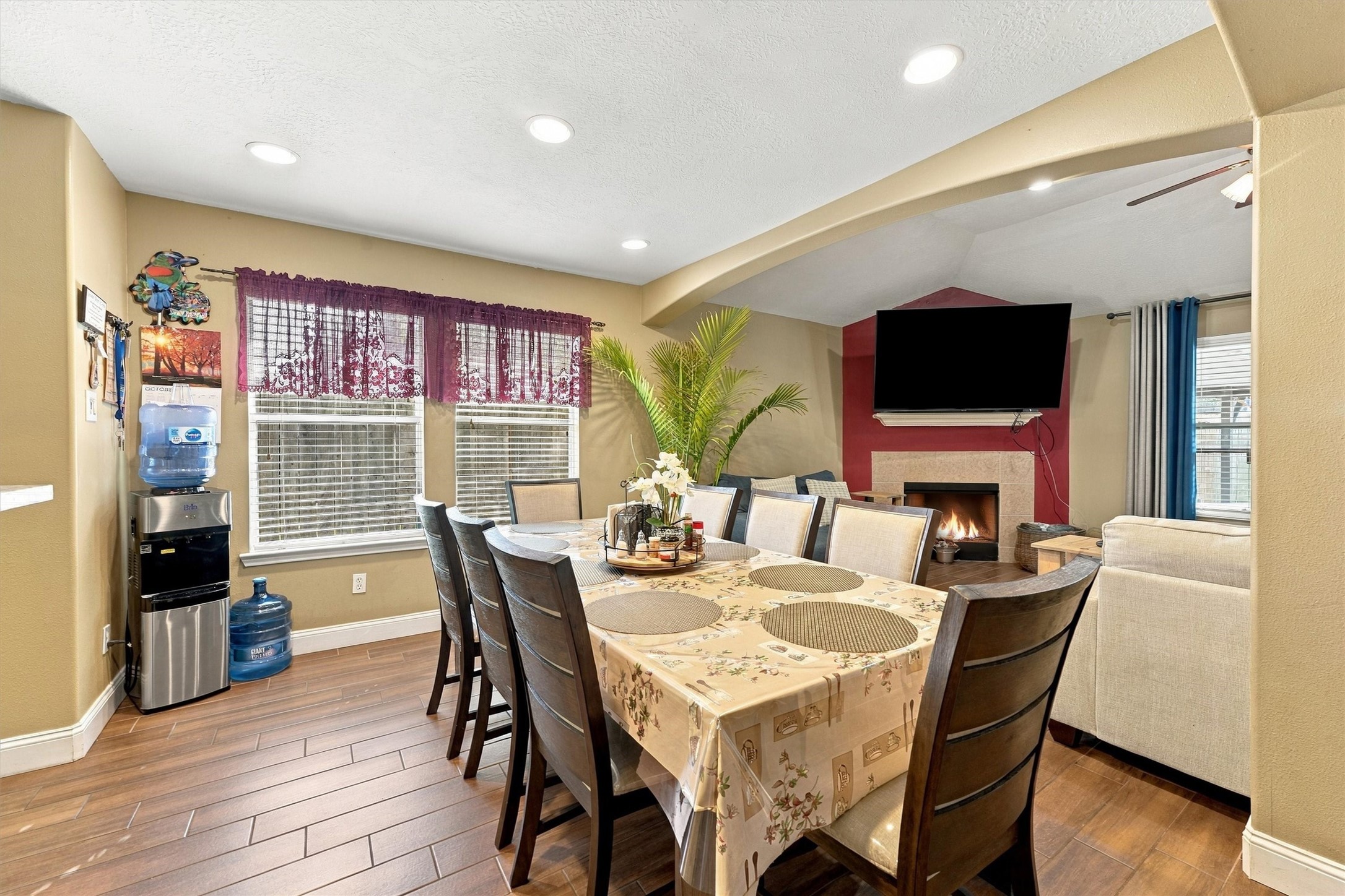 Spacious dining area and a cozy living room featuring a fireplace and mounted TV, perfect for entertaining.