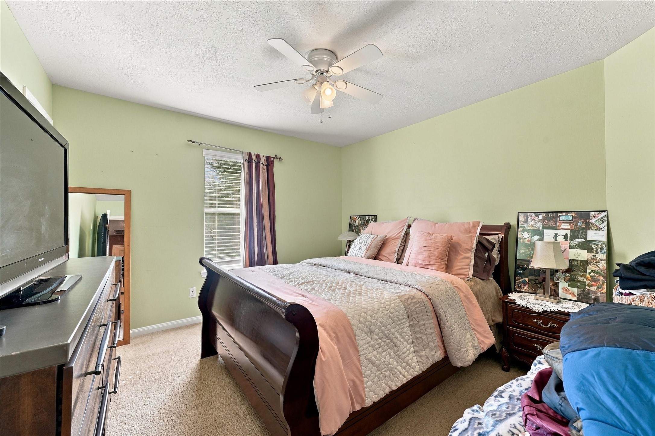 Cozy bedroom with ample natural light through a large window.
