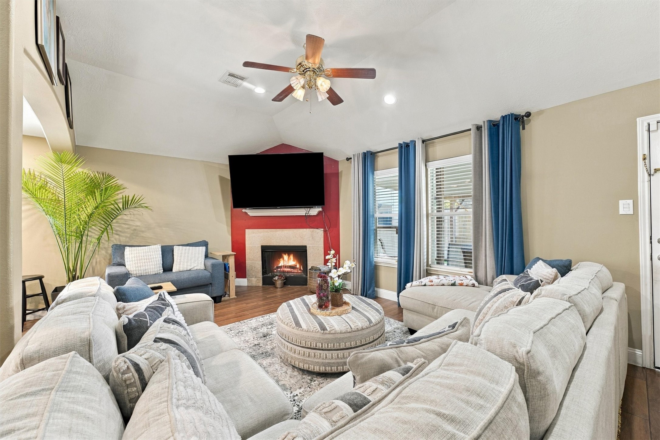Spacious living room with cozy fireplace, vaulted ceiling, and abundant natural light.
