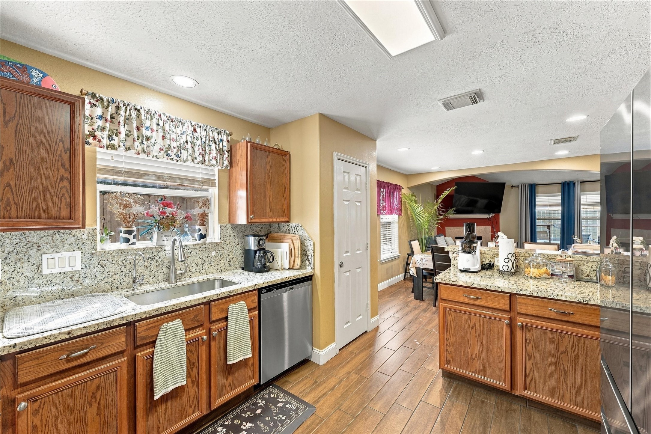 Charming kitchen with granite countertops, warm wood cabinetry, and a cozy dining area, perfect for family gatherings.