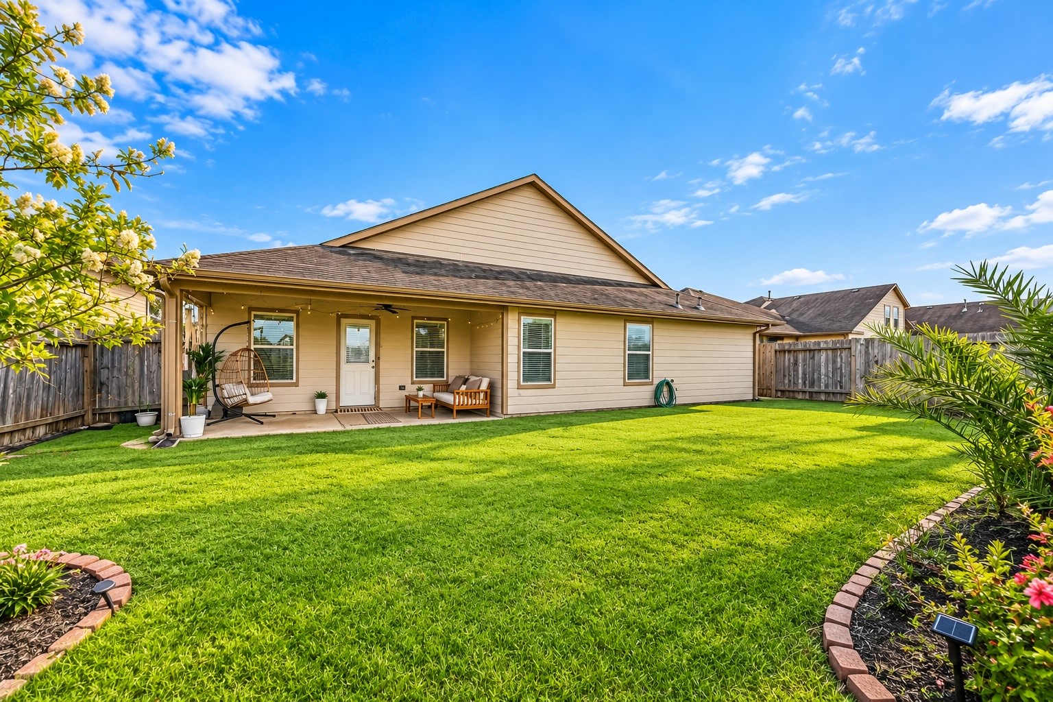 Enjoy a spacious, private backyard with a covered patio, inviting seating area, and plenty of green space for relaxing outdoors, entertaining, or enjoying a quiet afternoon at home.
